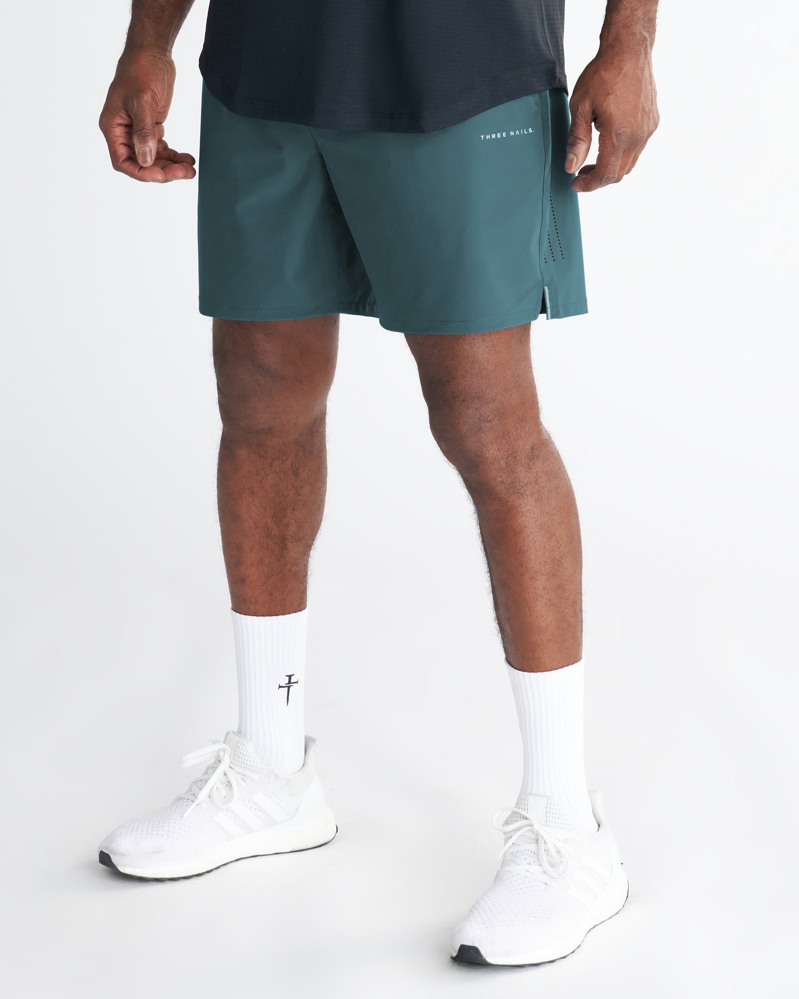 Front view of the Vapor-Lite Hybrid Short in Teal, shown on a model paired with white sneakers and socks.