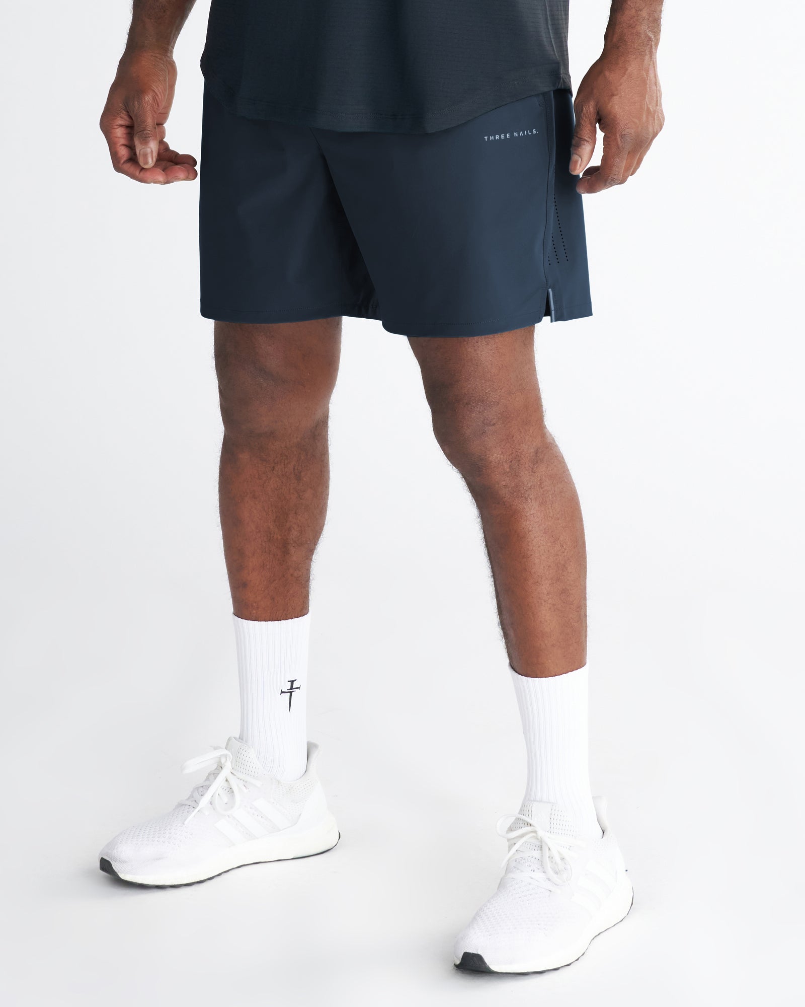 Front view of the Vapor-Lite Hybrid Short in Midnight Navy worn by a male model with white sneakers and socks.