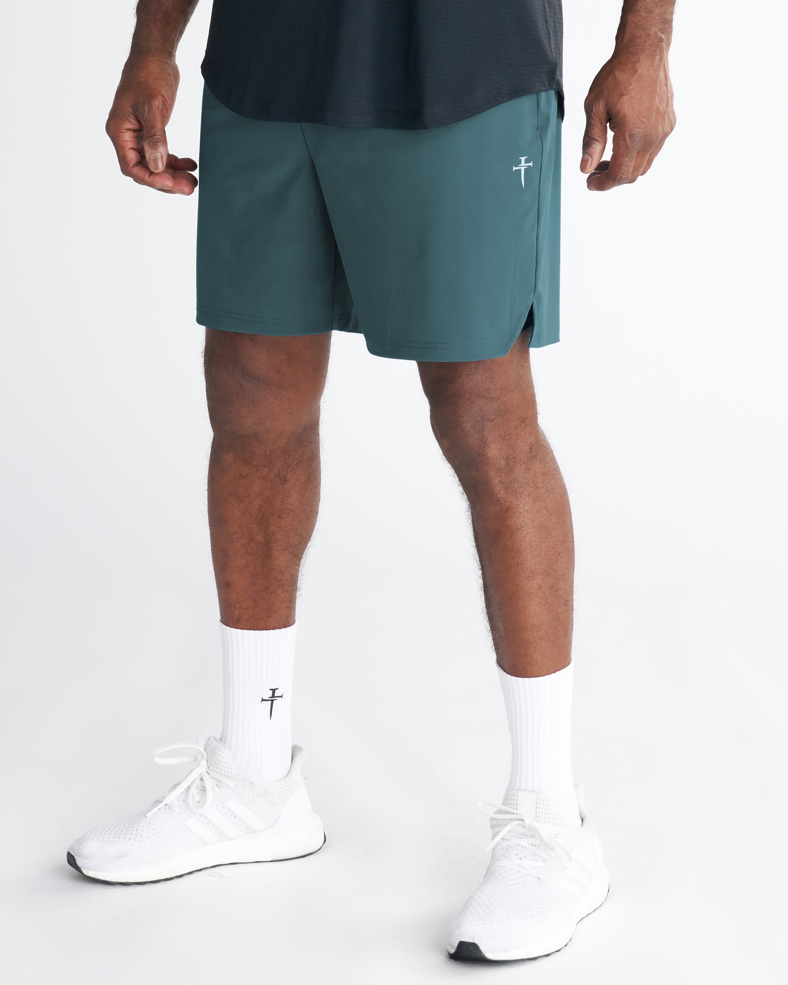 Front view of Vapor-Lite Liner Short Cross in teal worn by a male model with white sneakers and branded socks.