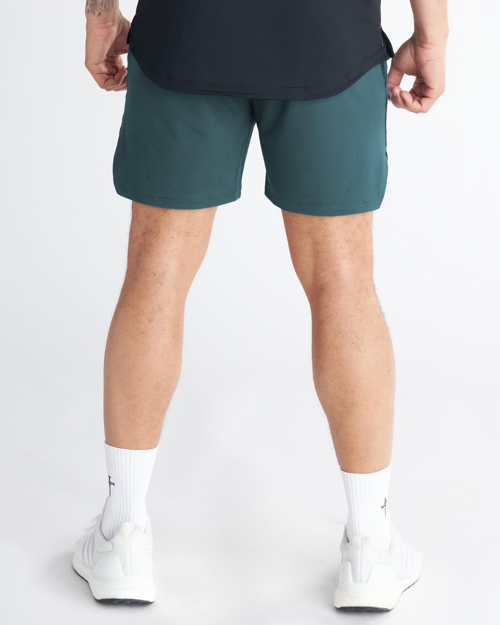 Back view of the Pro-Tech 2.0 Linerless Short in Teal, paired with white sneakers and crew socks.
