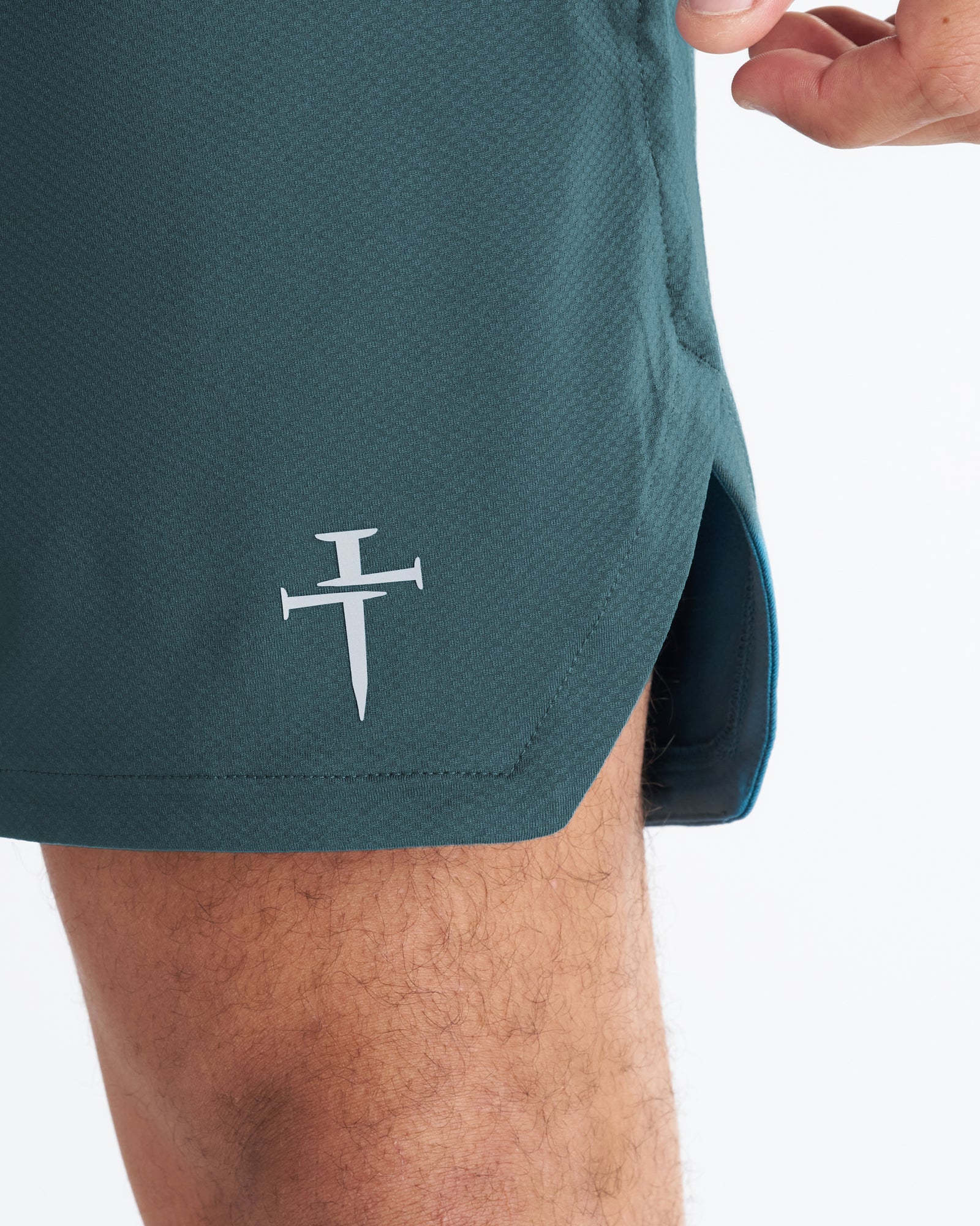 Close-up of the Pro-Tech 2.0 Linerless Short in Teal showing the Three Nails logo detail on the hem.