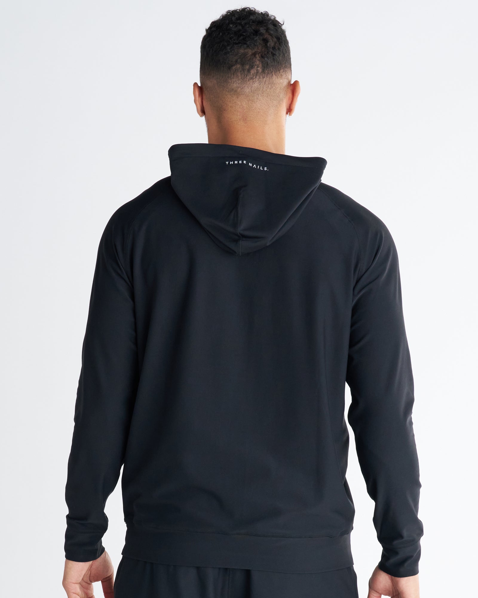 Haven Performance Hoodie in black, back view on male model showing hood detail and clean raglan seams.