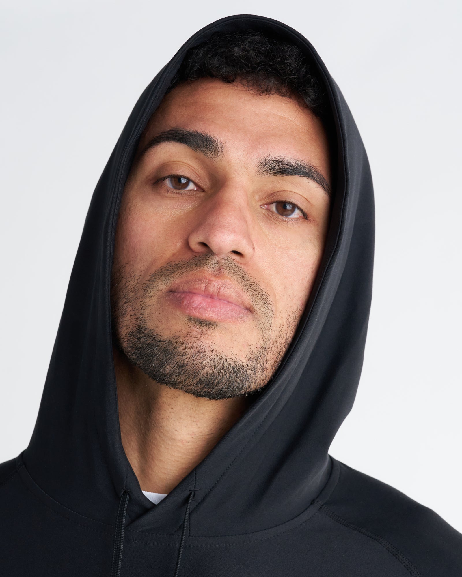 Close-up of model wearing the Haven Performance Hoodie in black, showing hood and neckline detail.