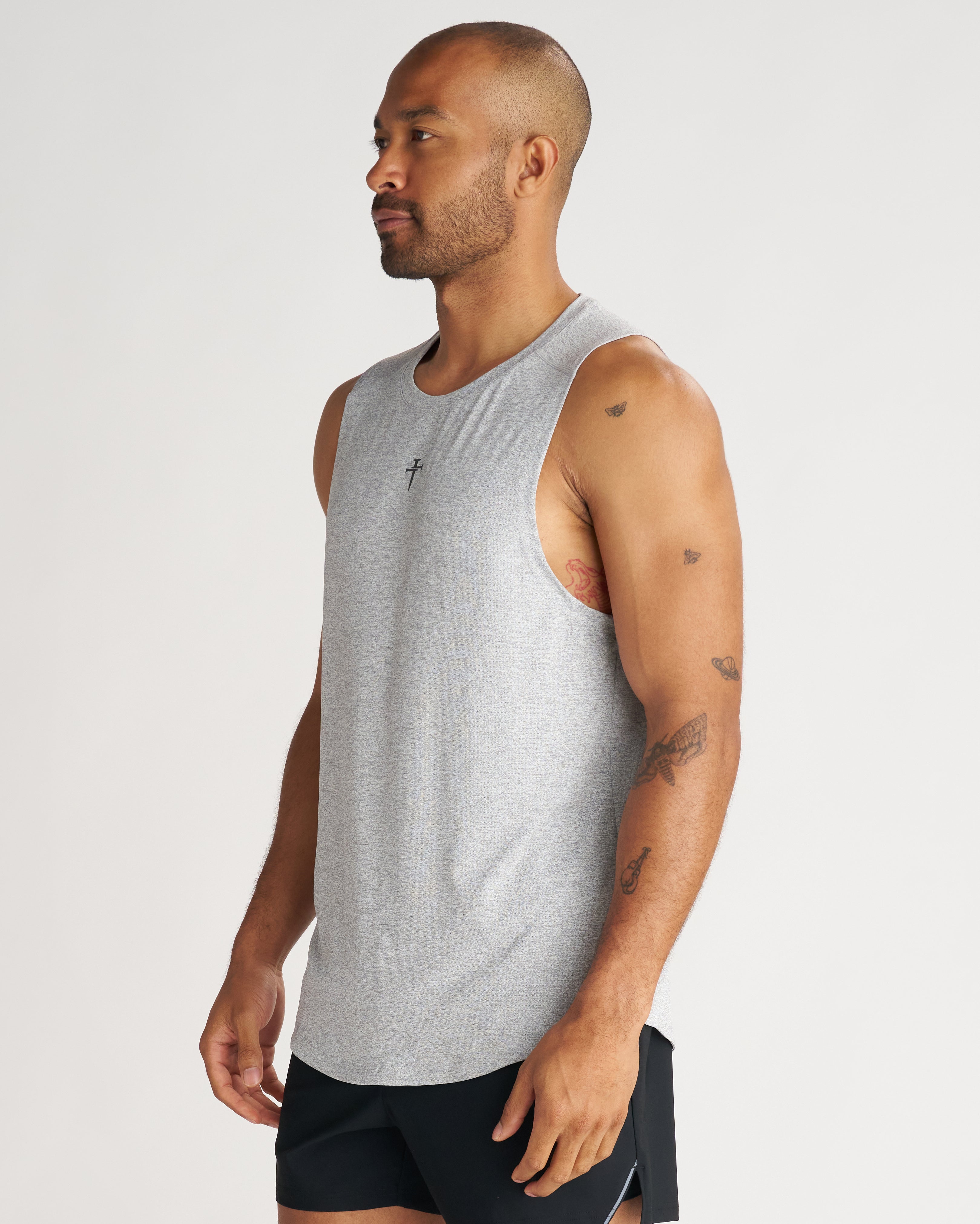 Aion-Lite Tank in Grey Marl on a male model, side angle view, sleeveless with a cross logo at chest.