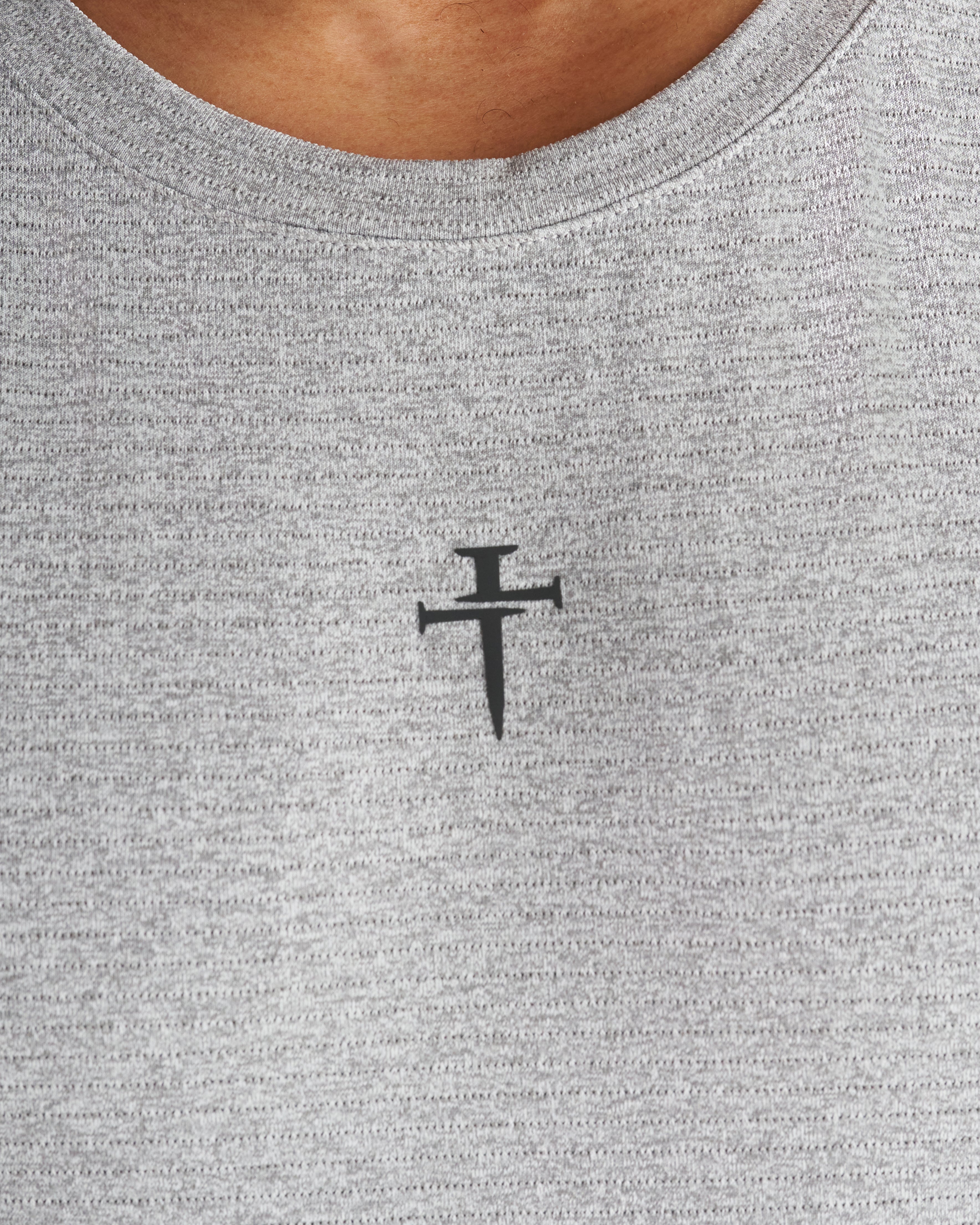 Close-up of the Three Nails cross logo printed on the chest of the grey marl Aion-Lite™ Tank.