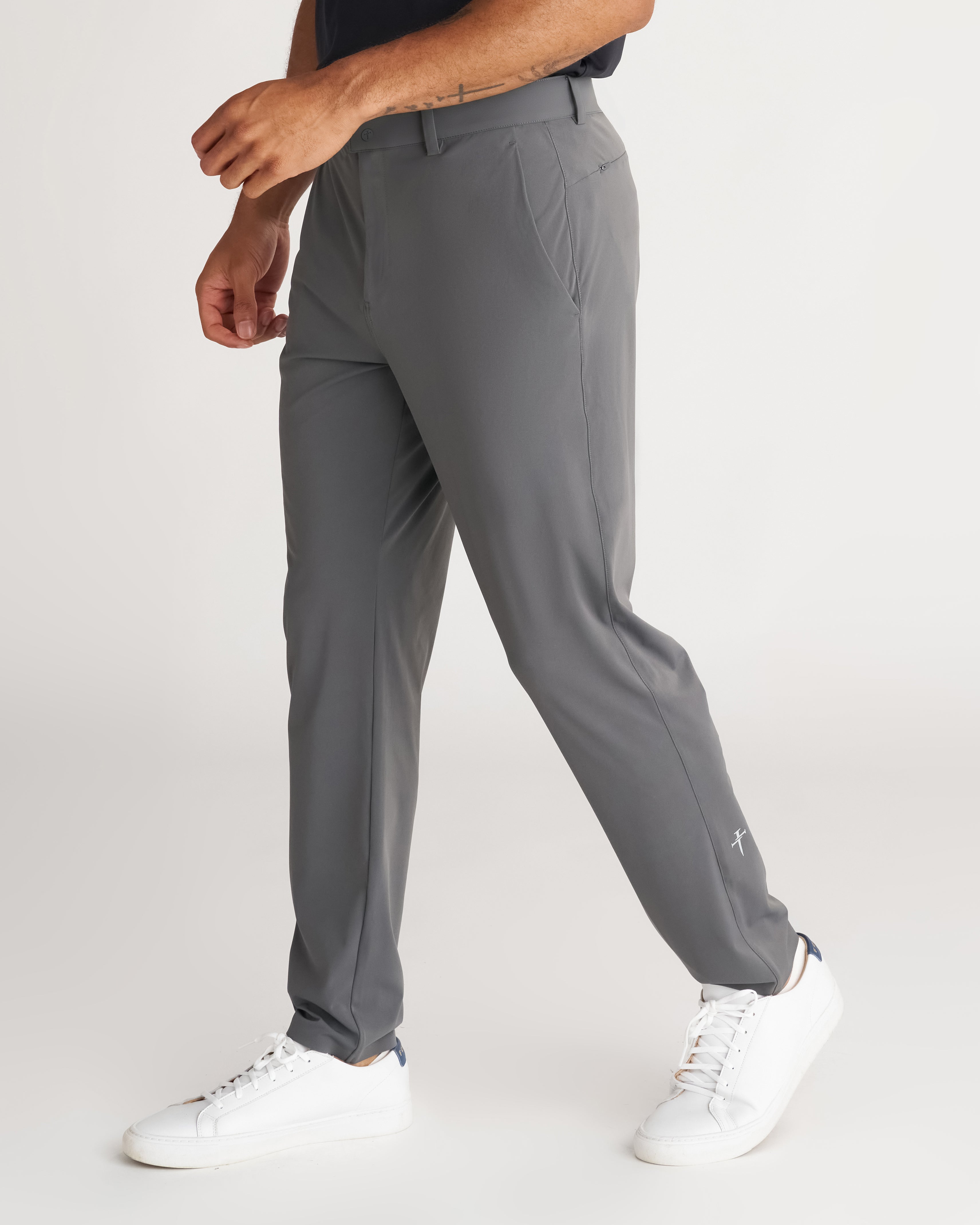 Links Golf Pant in Space Grey on a male model shown from a side angle, featuring a slim tapered fit and white sneakers.