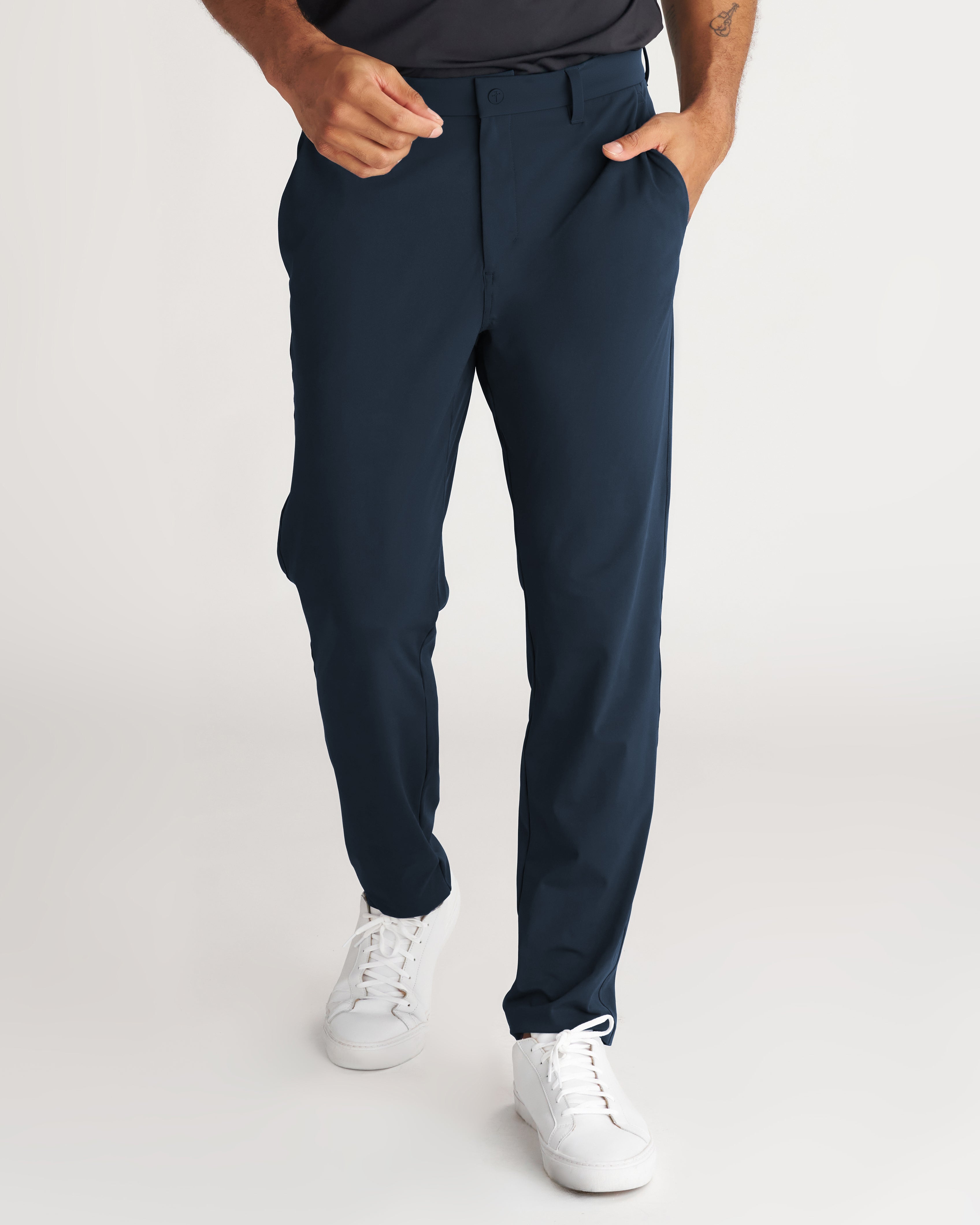 Links Golf Pant in Midnight Navy, front view on a model wearing white sneakers, hands in pockets.