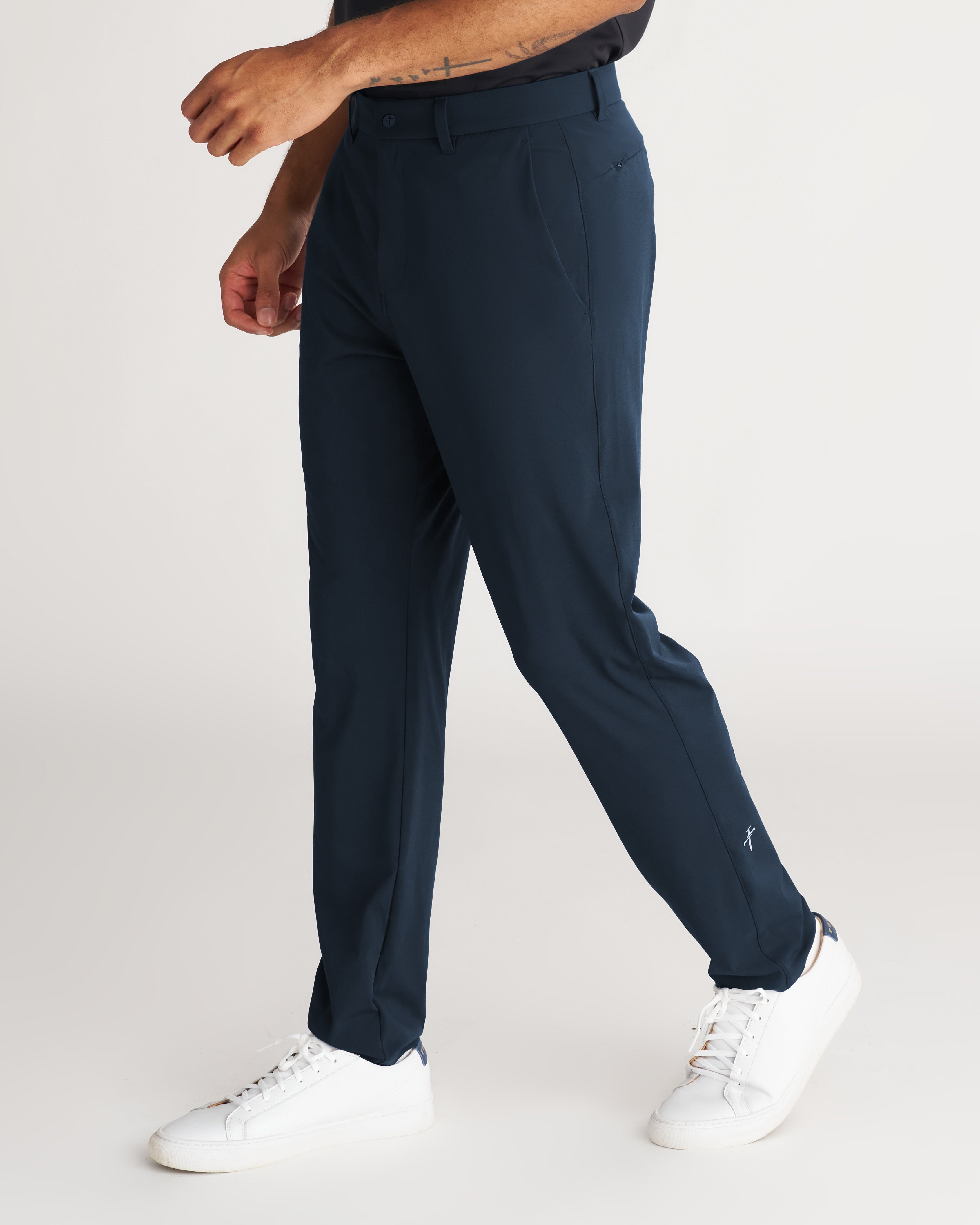 Links Golf Pant in Midnight Navy on a male model shown from a side angle, featuring a slim tailored fit and white sneakers.
