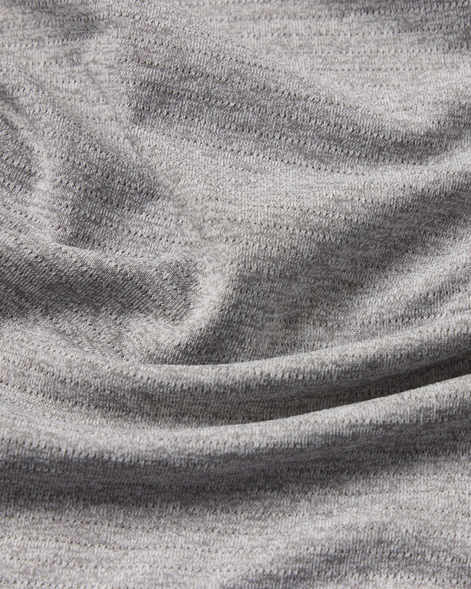 Close-up of the grey marl fabric texture on the Aion-Lite Tee Cross showing the fine knit weave and natural drape.
