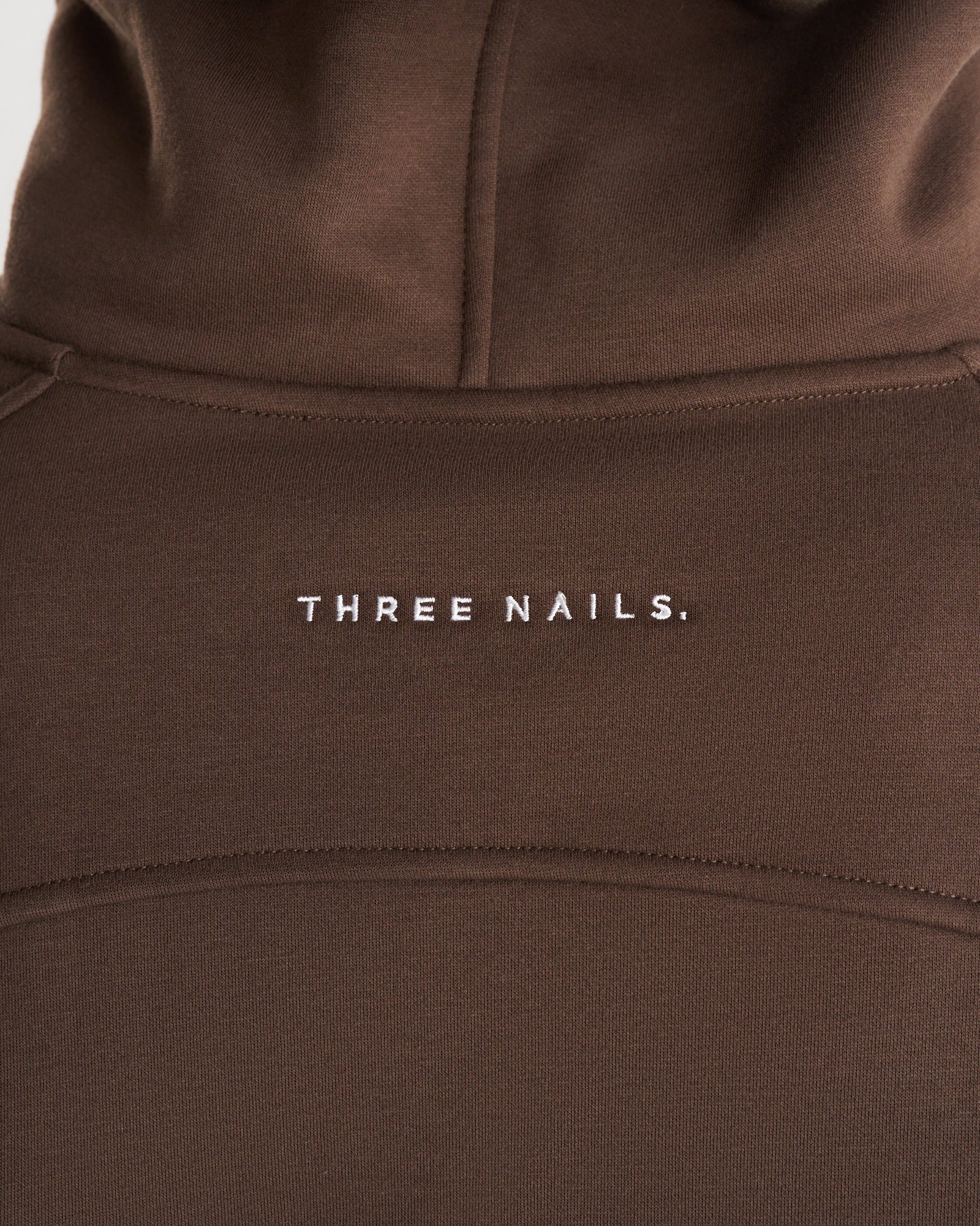 Close-up of the chest area on the Signature Fleece Hoodie in Woodland Brown showing embroidered Three Nails wordmark.