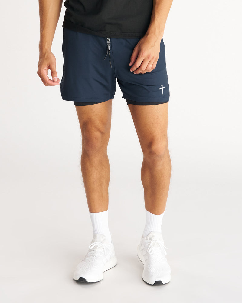 Front view of Pro-Tech 2.0 Liner 5" Short Bundle Pack in navy worn by male model with white sneakers.