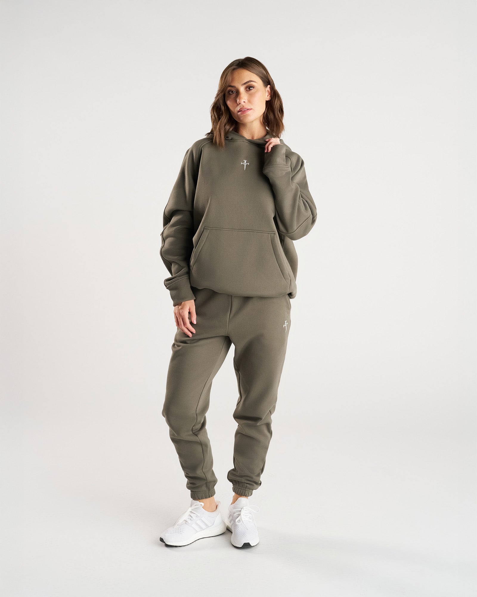 Signature Fleece Sweatpants in Sage worn by a model, front view, paired with matching hoodie and white sneakers.