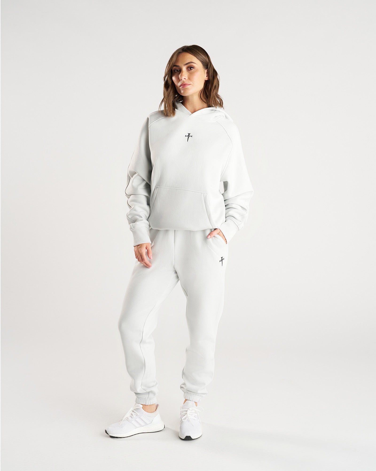 Model in front view wearing Stone Signature Fleece Sweatpants with matching hoodie and white sneakers.