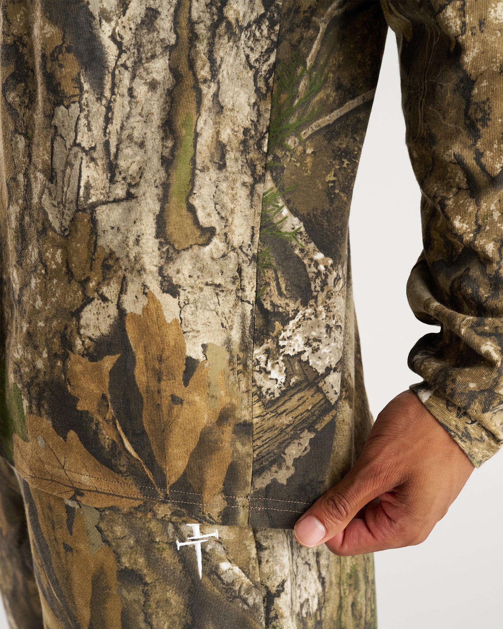 Close-up detail of the Heavyweight Cotton Oversized Long Sleeve FHG in Realtree Camo showing side seam and pocket opening.