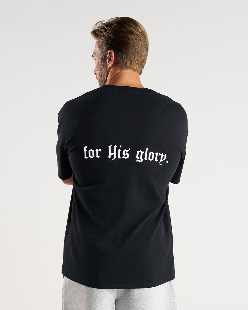 Back view of model wearing the FHG Heavyweight Oversized Tee in black with for His glory text printed on back.