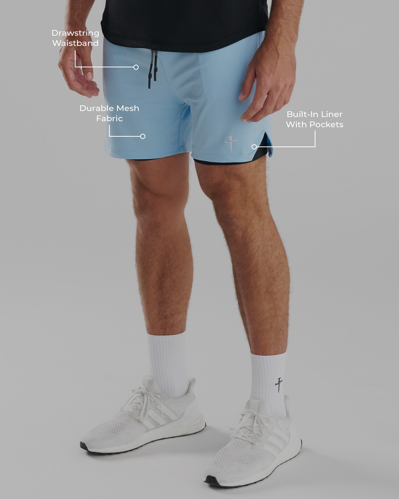 Man wearing sky blue Pro-Tech 2.0 Liner Short, side angle, with labeled features and white Adidas sneakers.