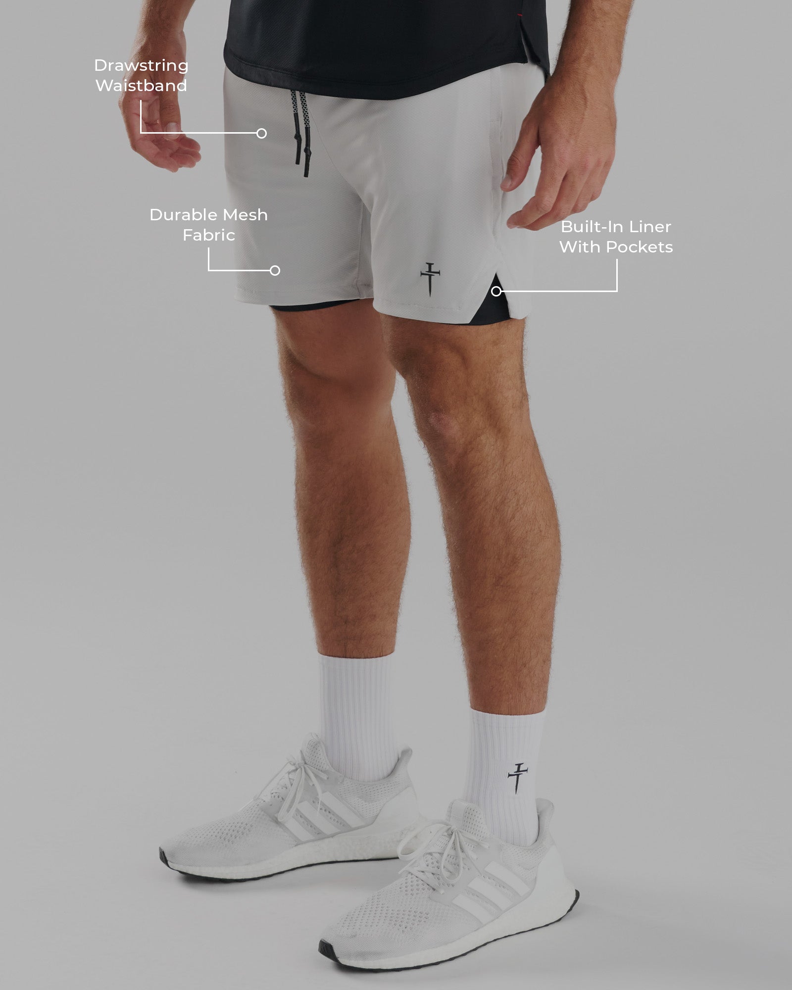 Man wearing Pro-Tech 2.0 Liner Short in Stone, side angle, with feature callouts for waistband, mesh fabric, and built-in liner.