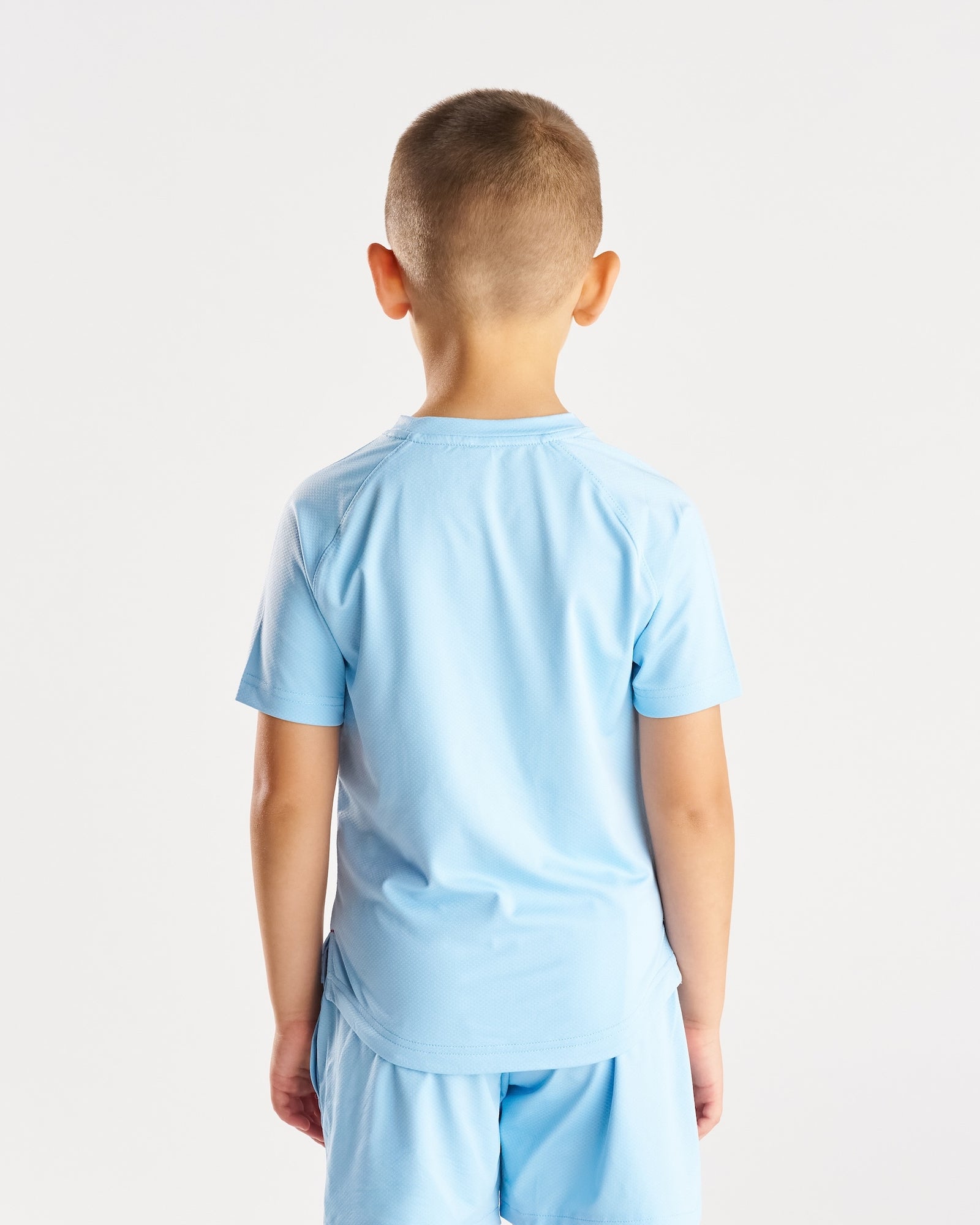 Youth Pro-Tech Tee Cross in Sky Blue shown from the back view on a young boy model.