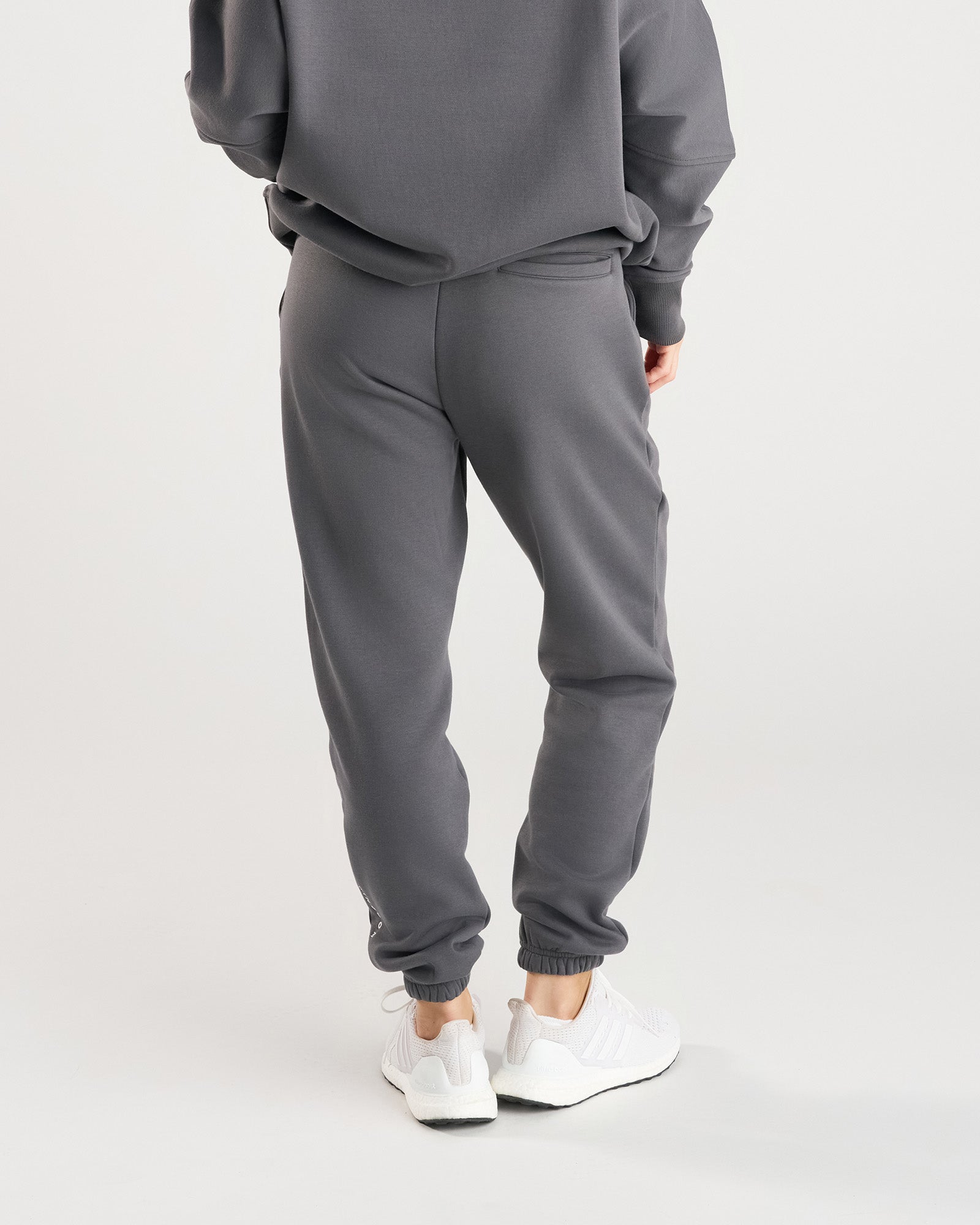Back view of Signature Fleece Sweatpants in Space Grey, styled with matching sweatshirt and white sneakers.