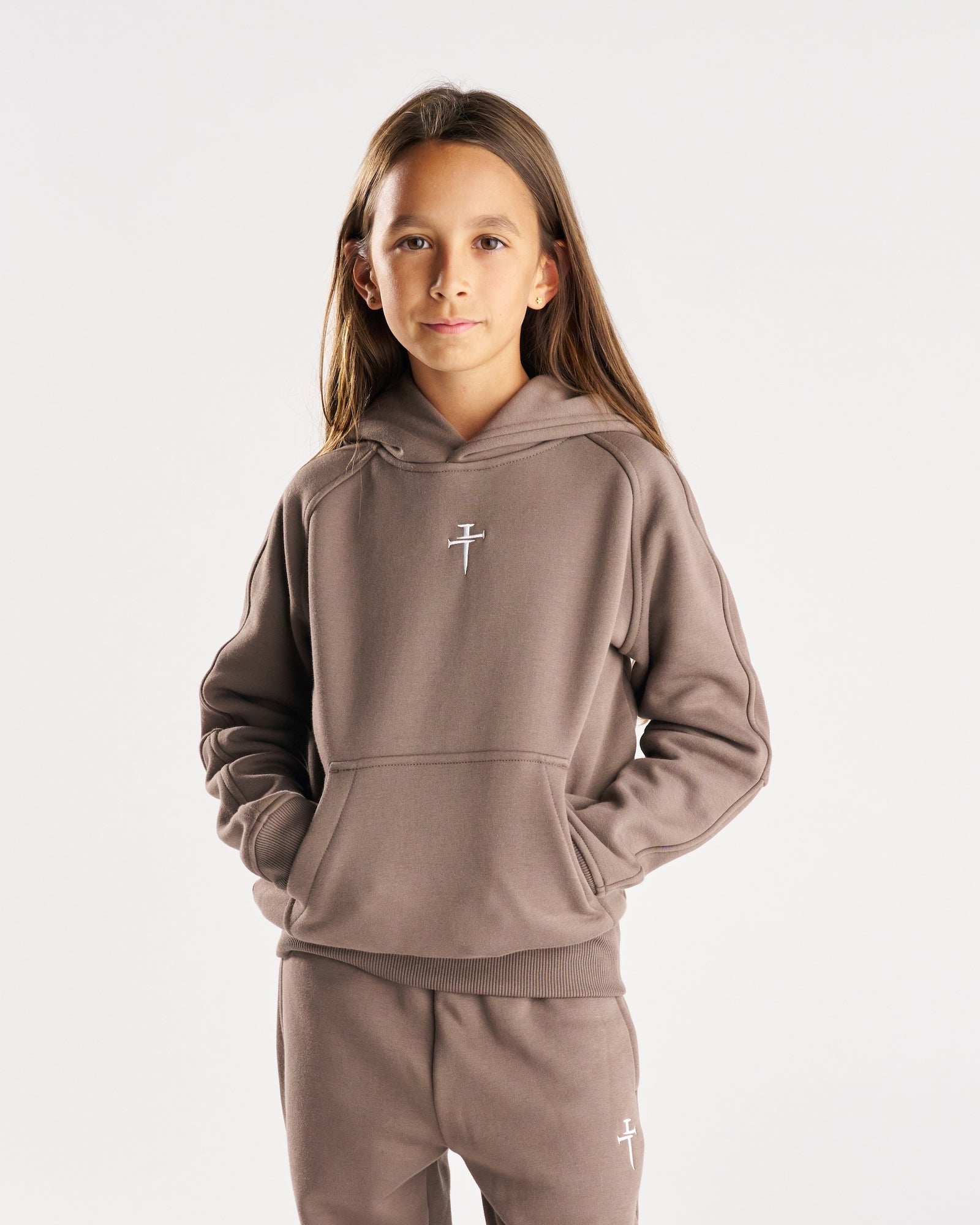 Youth Signature Fleece Hoodie in Deep Taupe, front view on a young girl model with hands in pocket.