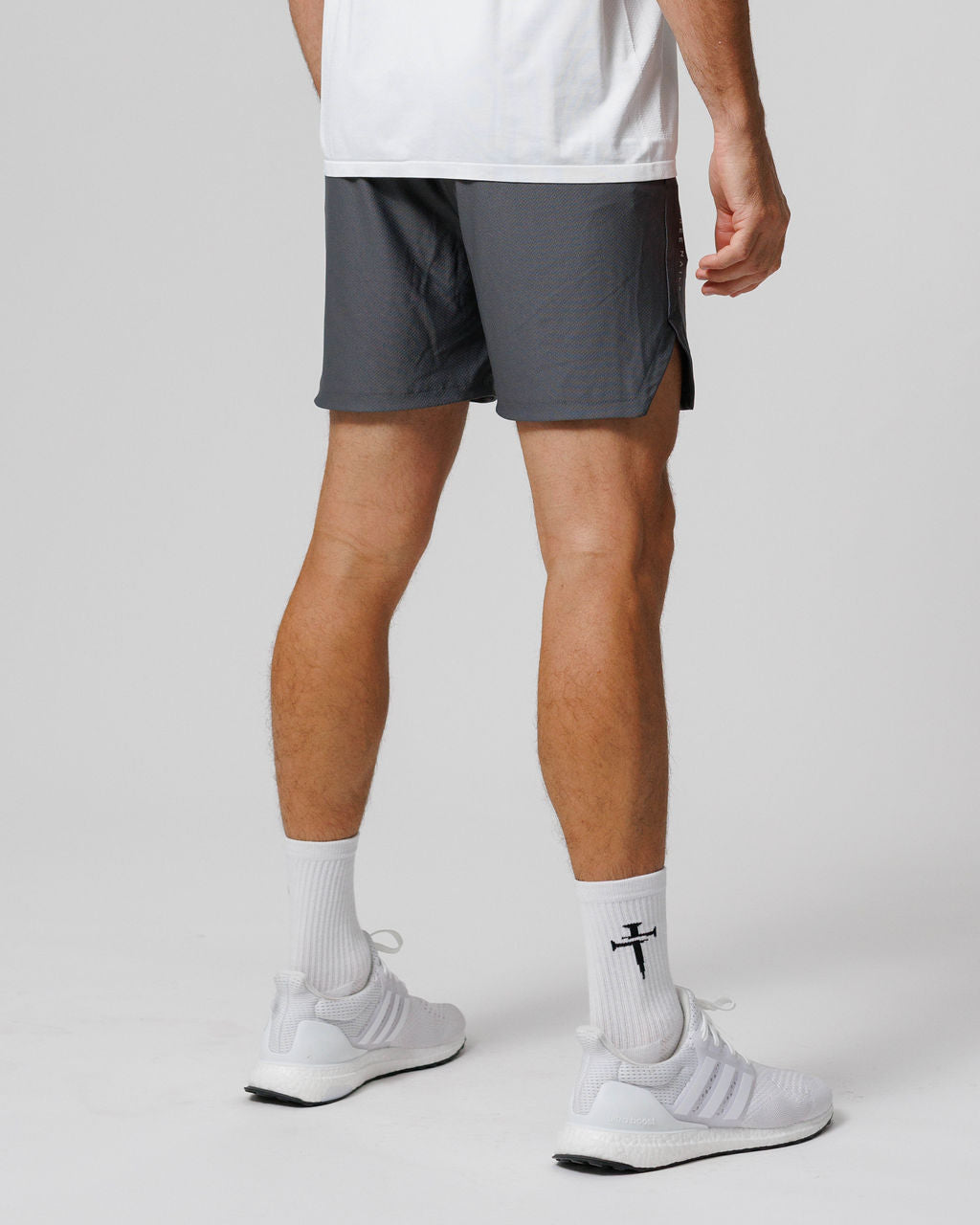 Pro-Tech 2.0 Linerless Short in Space Grey shown from a rear side angle on a male model wearing white sneakers.
