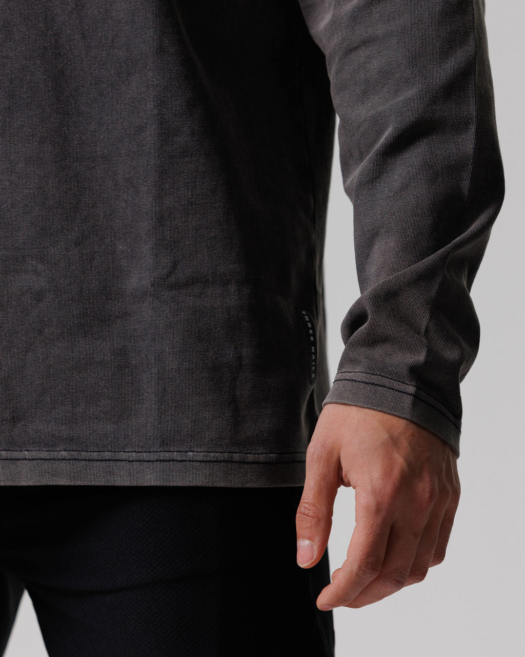 Close-up detail of Heavyweight Cotton Oversized Long Sleeve in Acid Wash showing ribbed cuff and hem stitching.