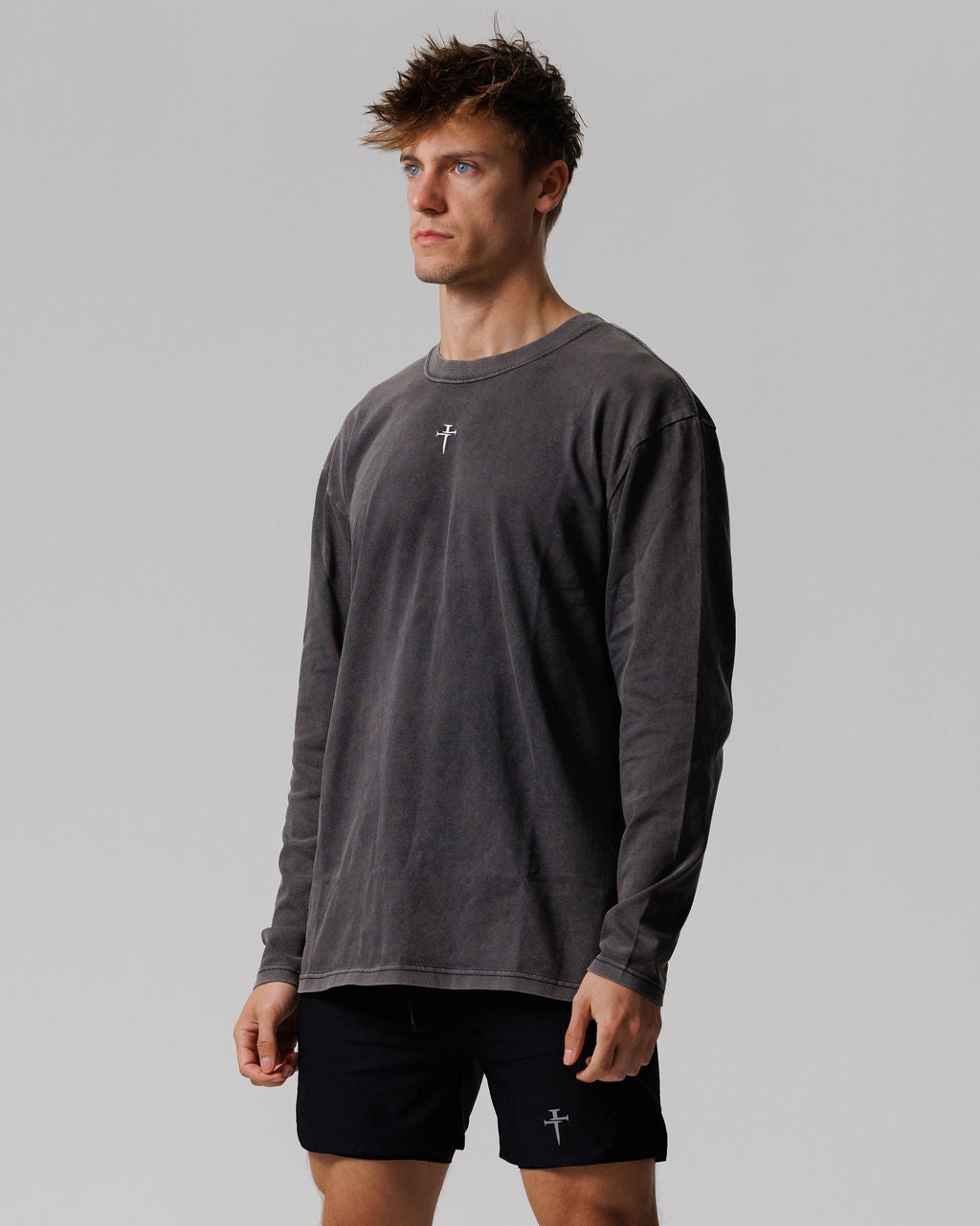 Male model wearing Heavyweight Cotton Oversized Long Sleeve in Acid Wash, slight side angle, with black shorts.