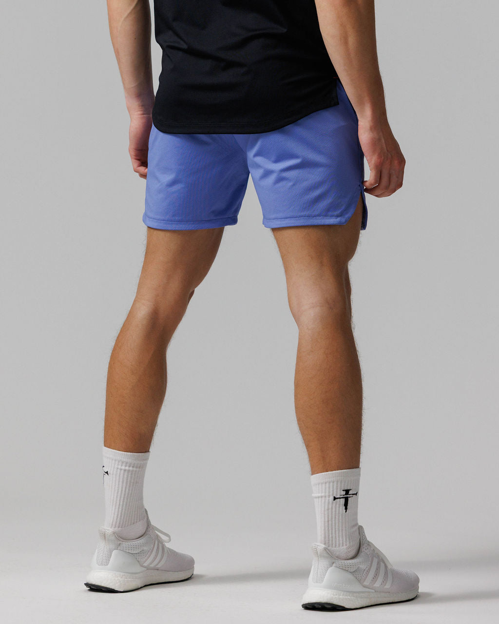 Pro-Tech 2.0 Linerless Short in Serene Blue shown from the back on a male model wearing white sneakers and socks.