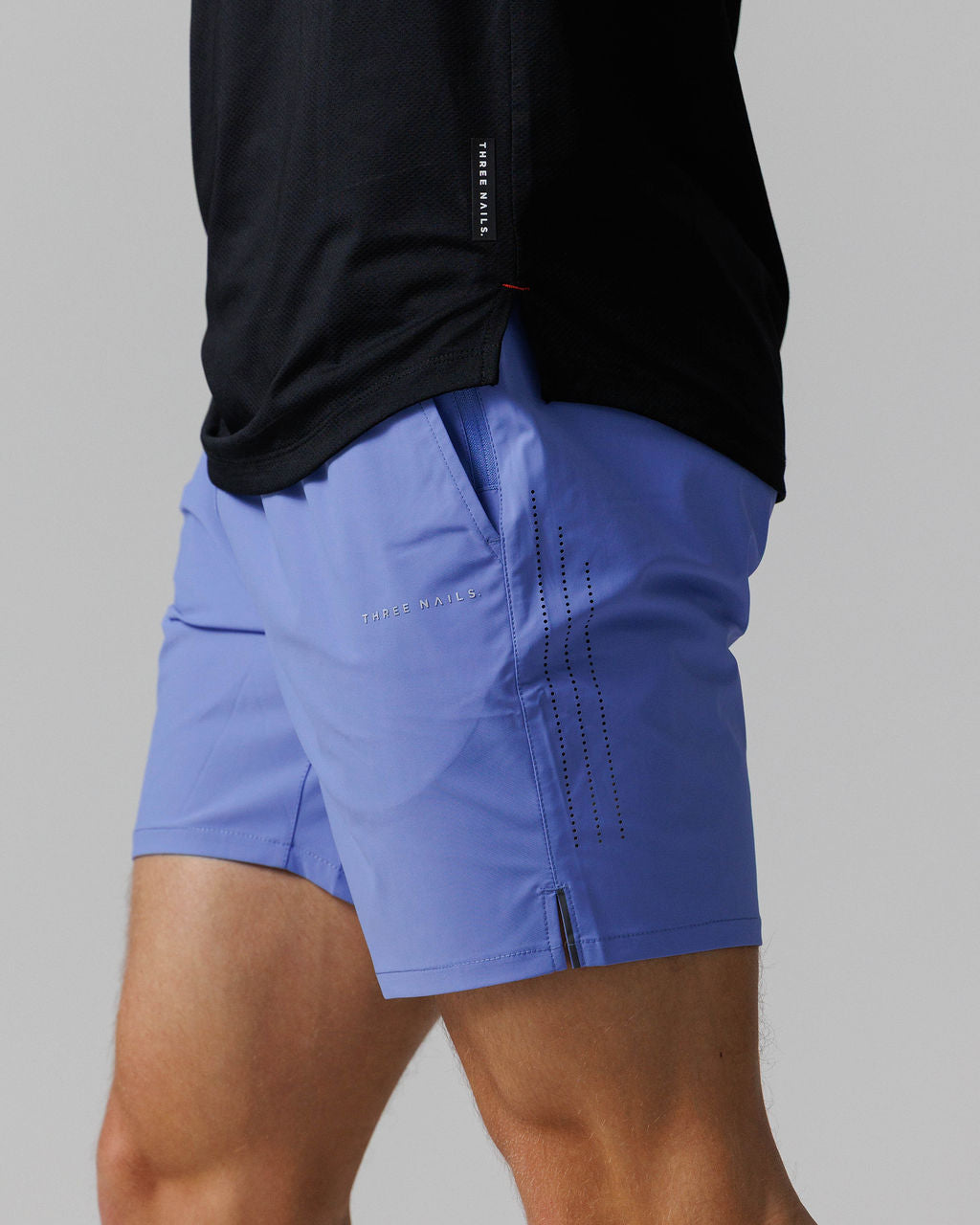 Side angle view of the Vapor-Lite™ Hybrid Short in Serene Blue, showing perforated side panel detail and brand logo.