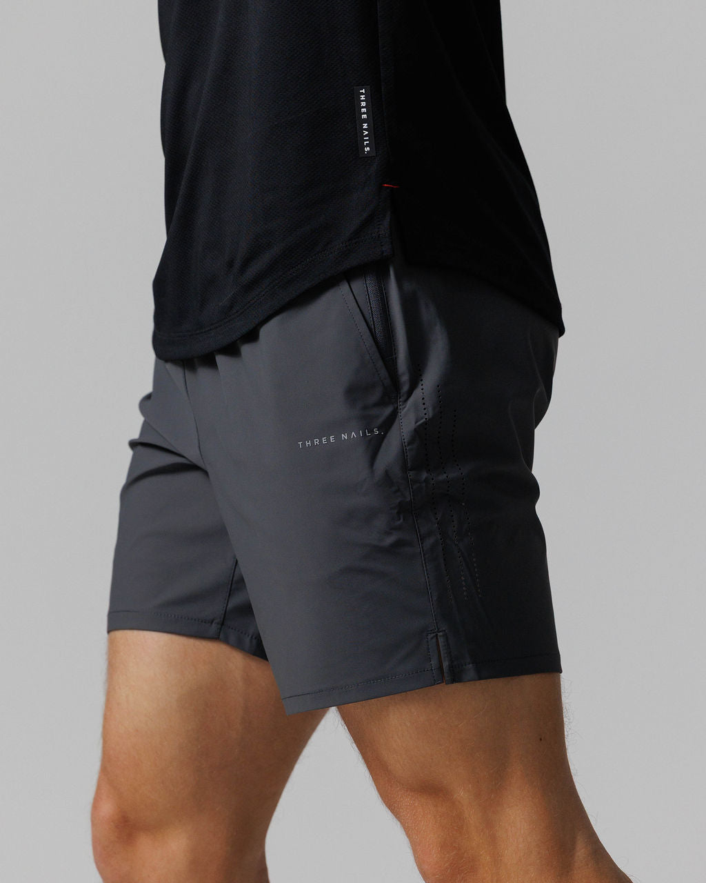 Side angle close-up of Vapor-Lite Hybrid Short in Space Grey, showing pocket detail and Three Nails logo.