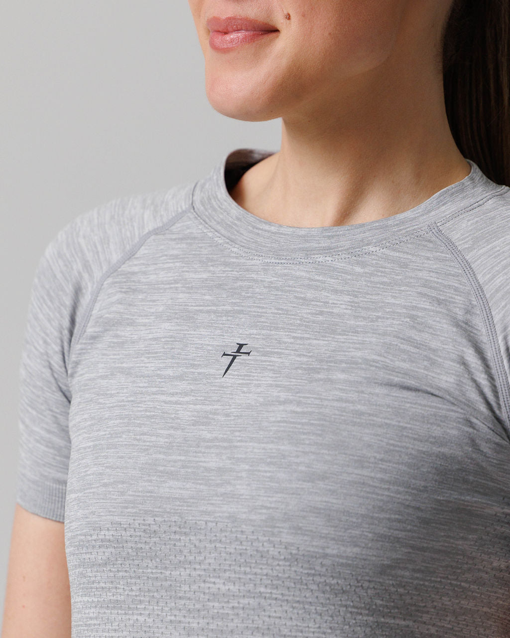 Close-up of Women's Seamless Tee Cross in Grey Marl showing the small cross logo on the chest.