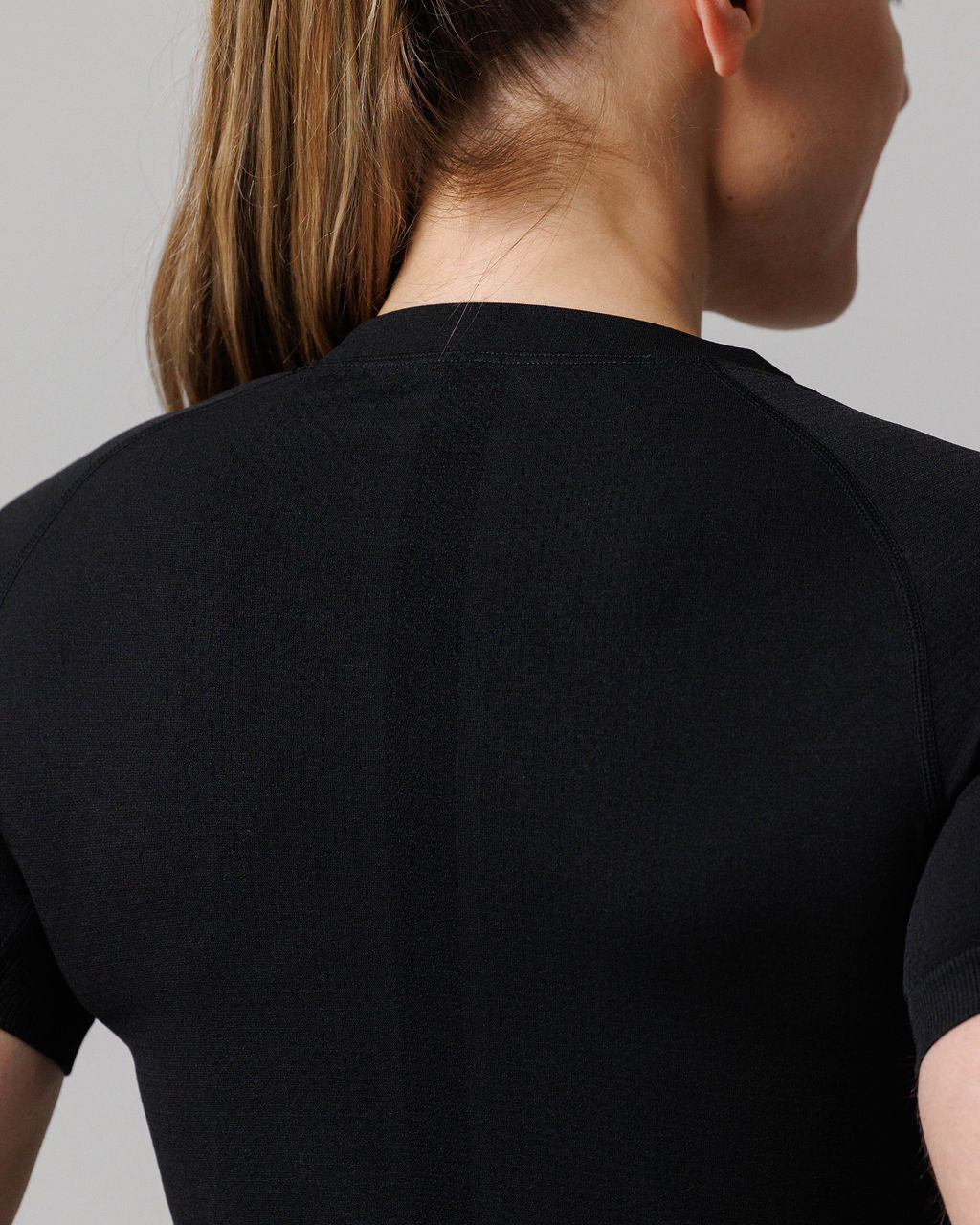 Back view close-up of Women's Seamless Tee Cross in black showing raglan seam detail and neckline.