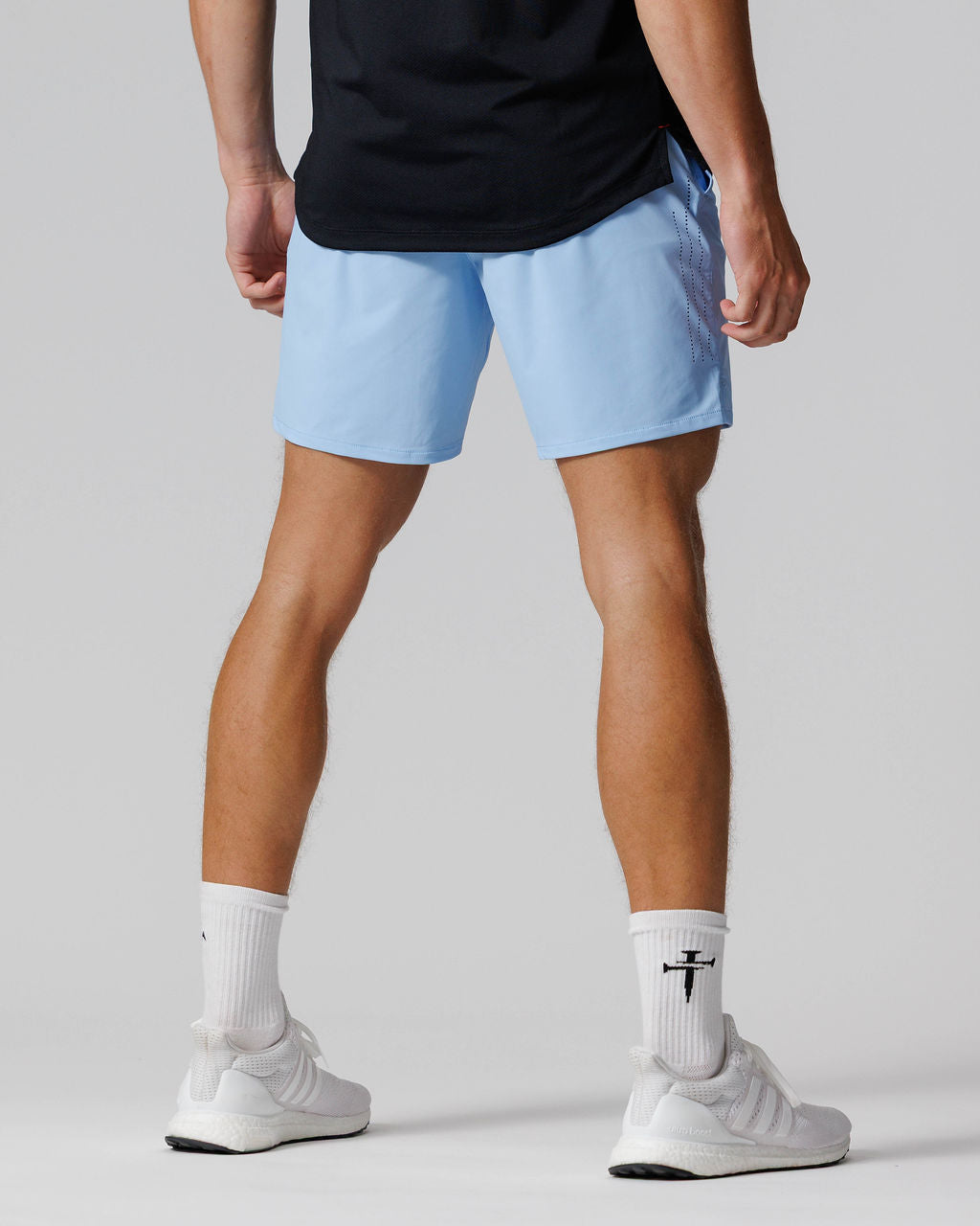 Back view of the Vapor-Lite Hybrid Short in Sky Blue, shown on a male model wearing white sneakers.