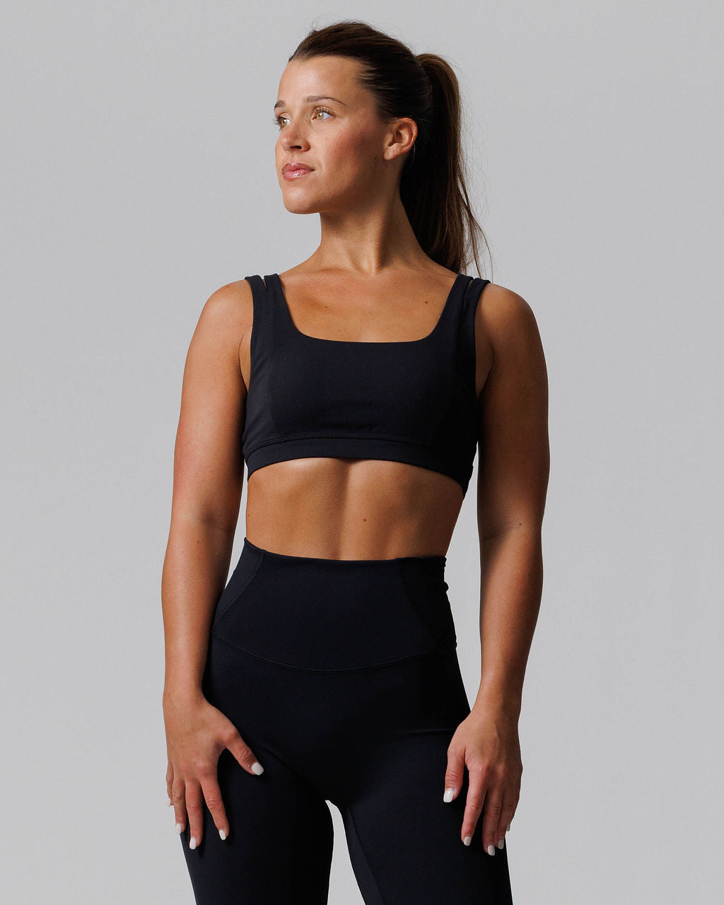 Nova Split-Strap Sports Bra in black, front view on model, featuring square neckline and double shoulder straps.