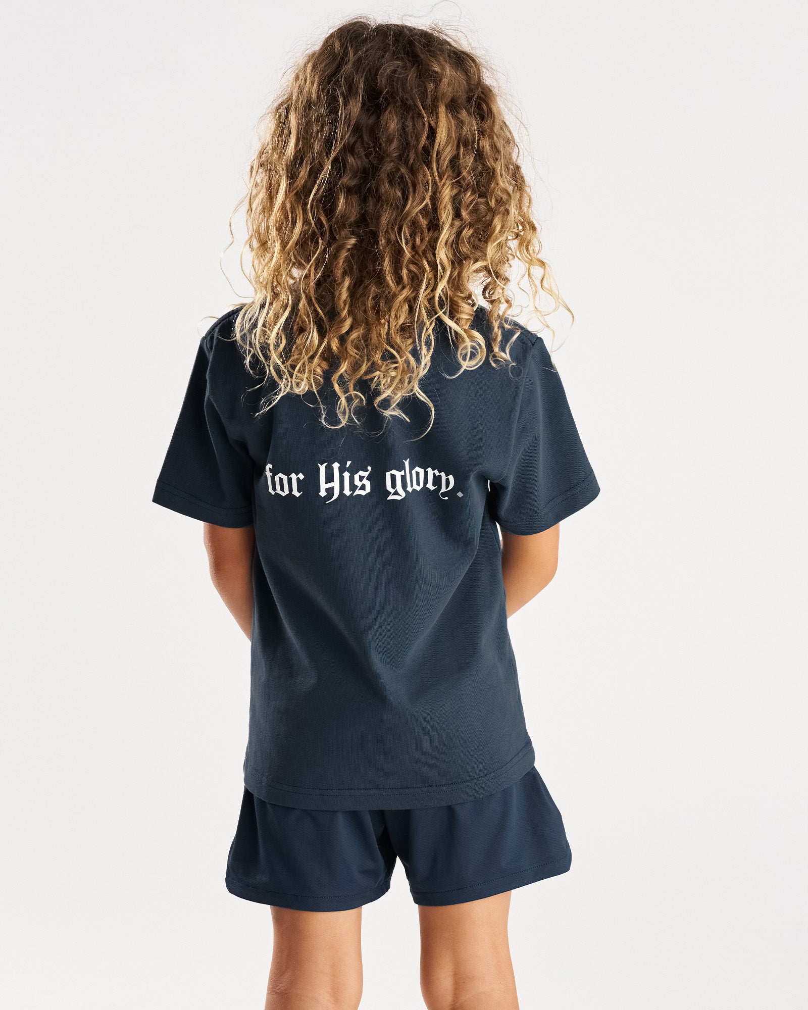 Youth Heavyweight Oversized Tee FHG in Midnight Navy, back view on child model showing for His glory graphic print.