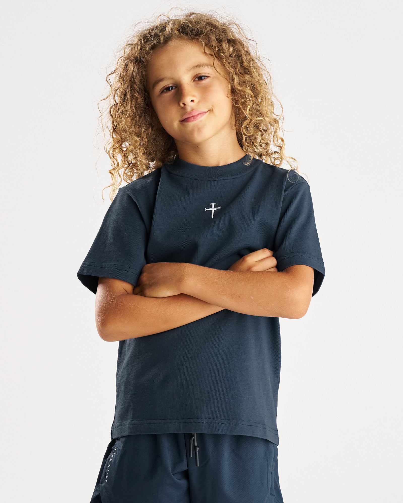 Youth Heavyweight Cotton Oversized Tee FHG in Midnight Navy, front view on a young model with arms crossed.