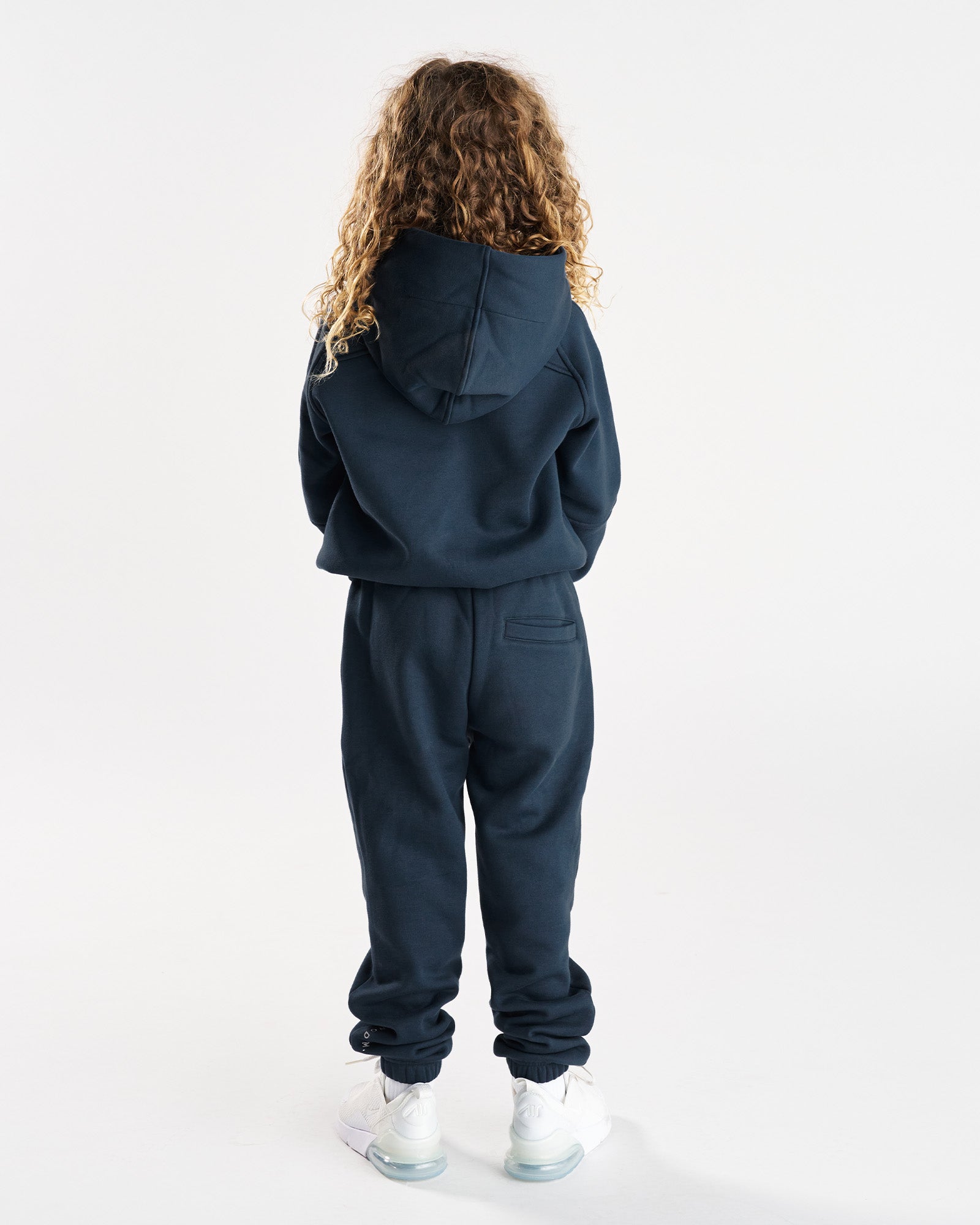 Youth Signature Fleece Hoodie in Midnight Navy shown from the back on a child model wearing the matching joggers.