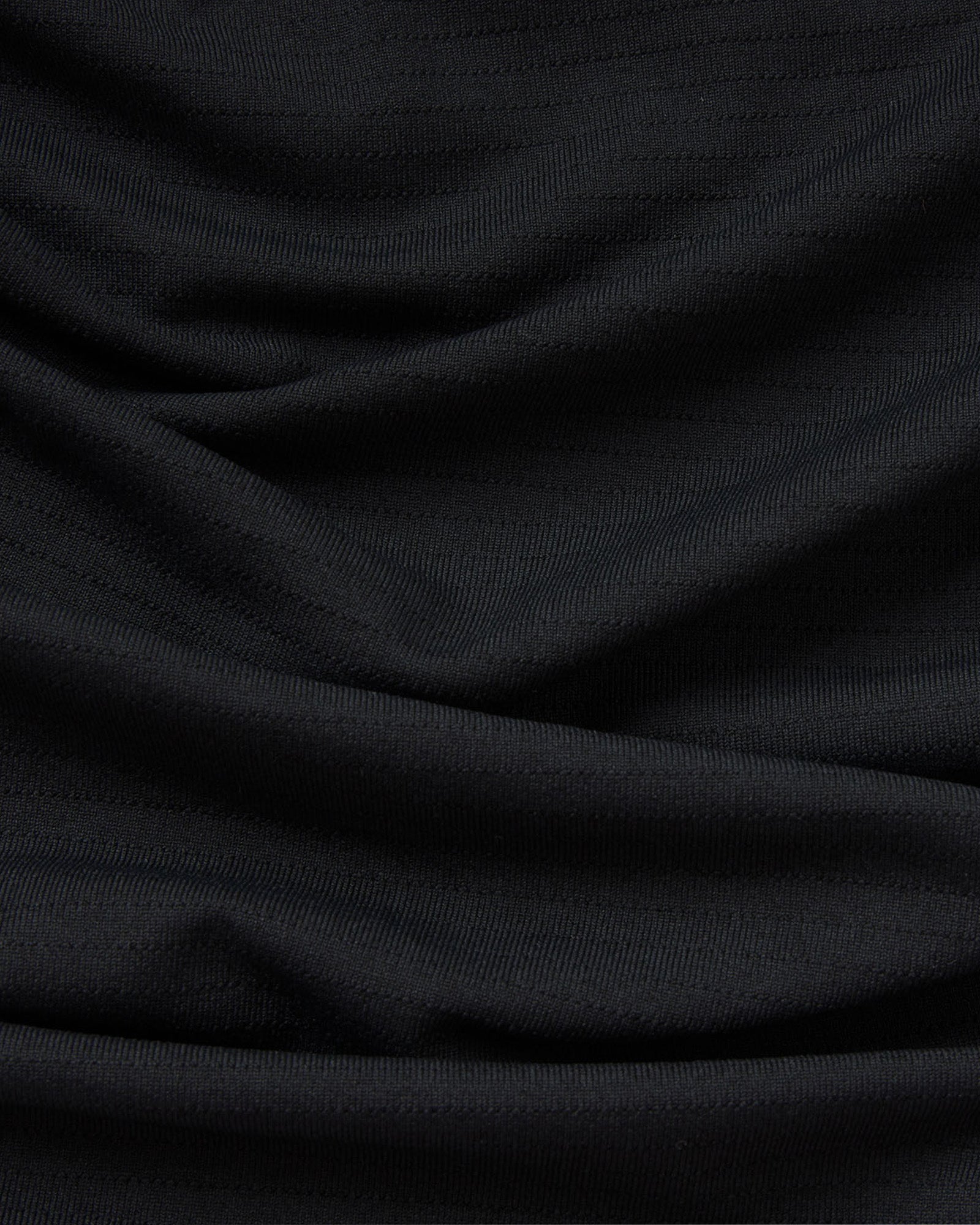 Close-up of the black Aion-Lite Tee Three Nails fabric texture showing smooth draping and fine knit detail.