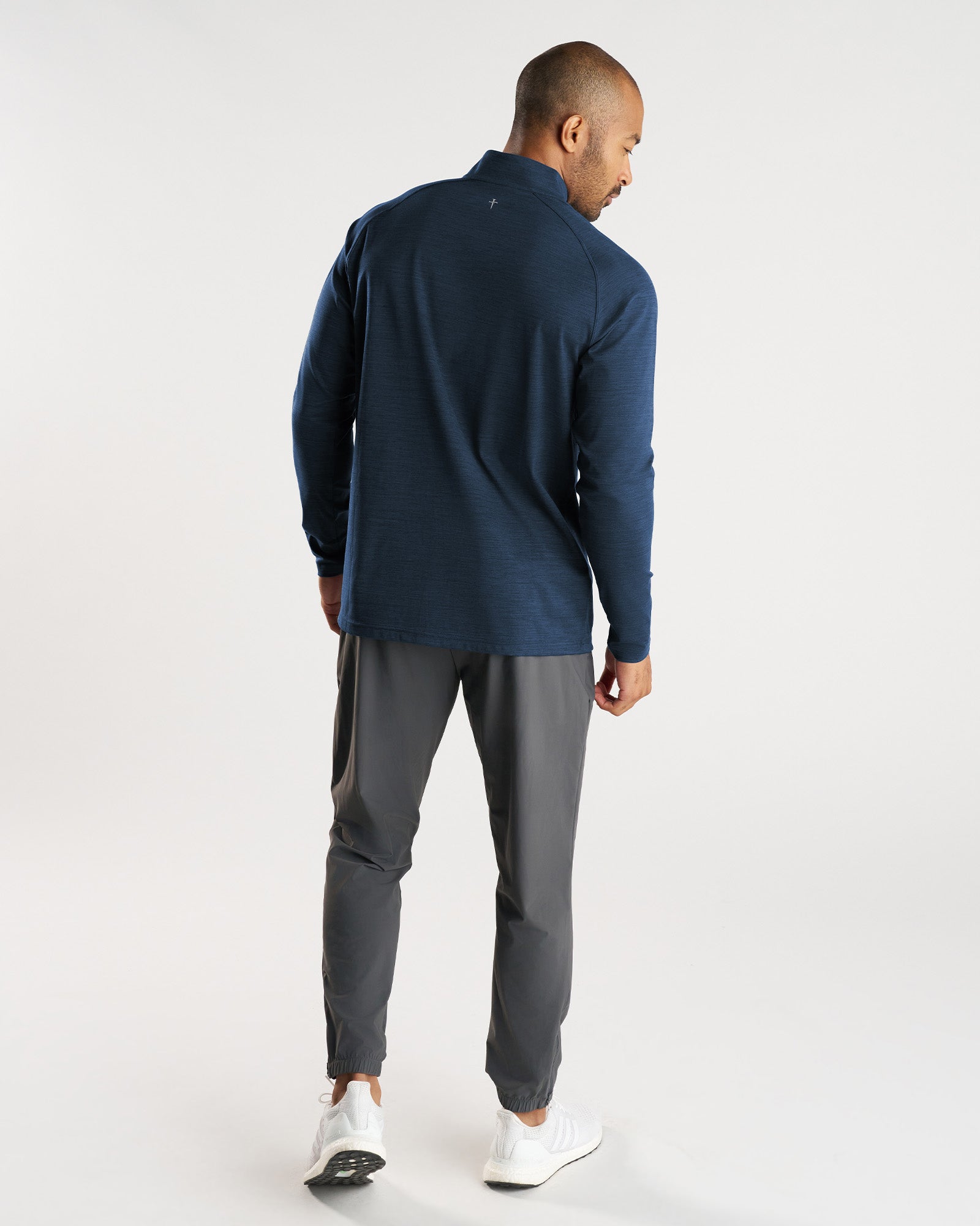 Back view of the Core Quarter Zip in Midnight Navy, paired with gray joggers and white sneakers.