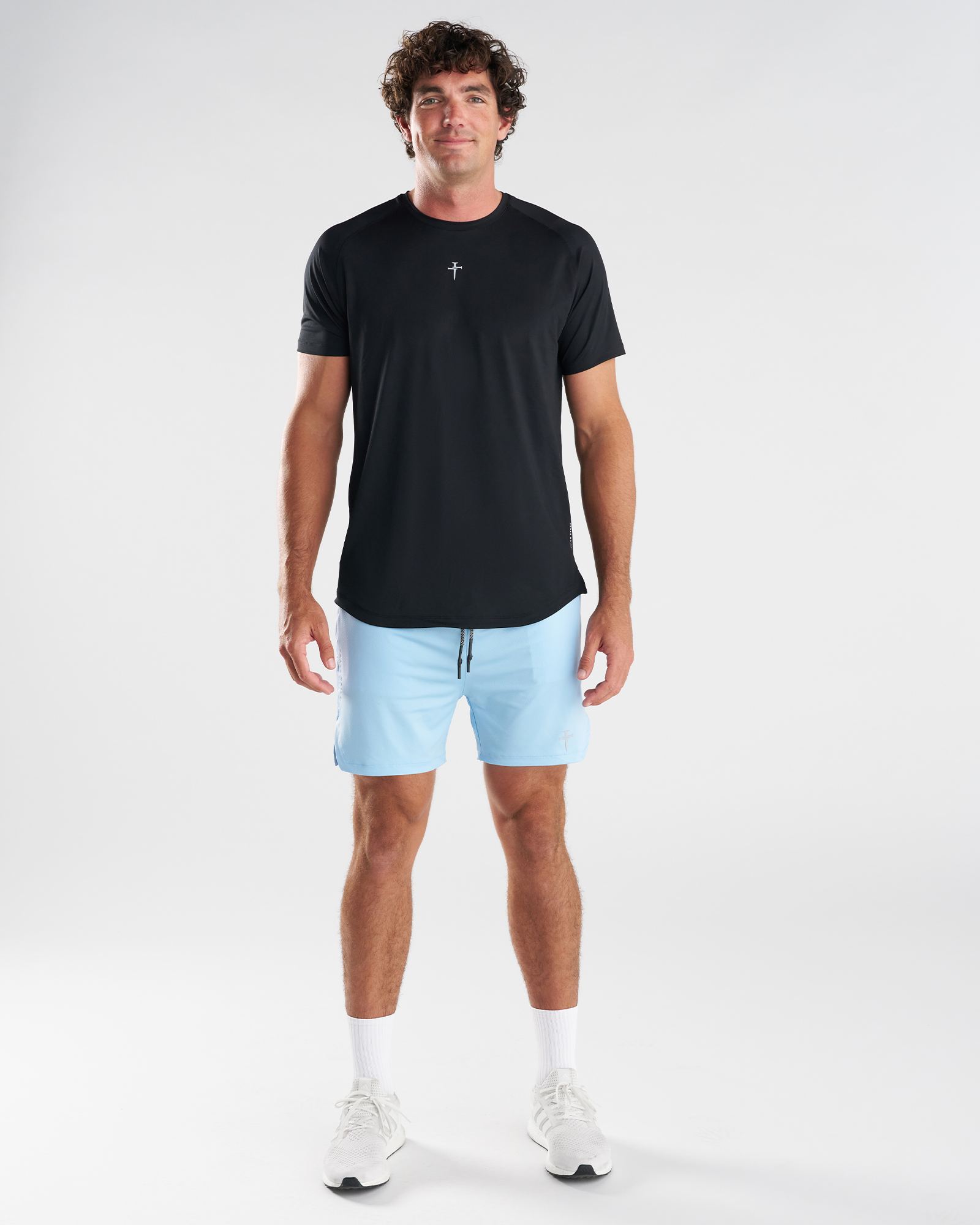 Man wearing Sky Blue Pro-Tech 2.0 Liner Shorts, front view, paired with black tee and white sneakers.
