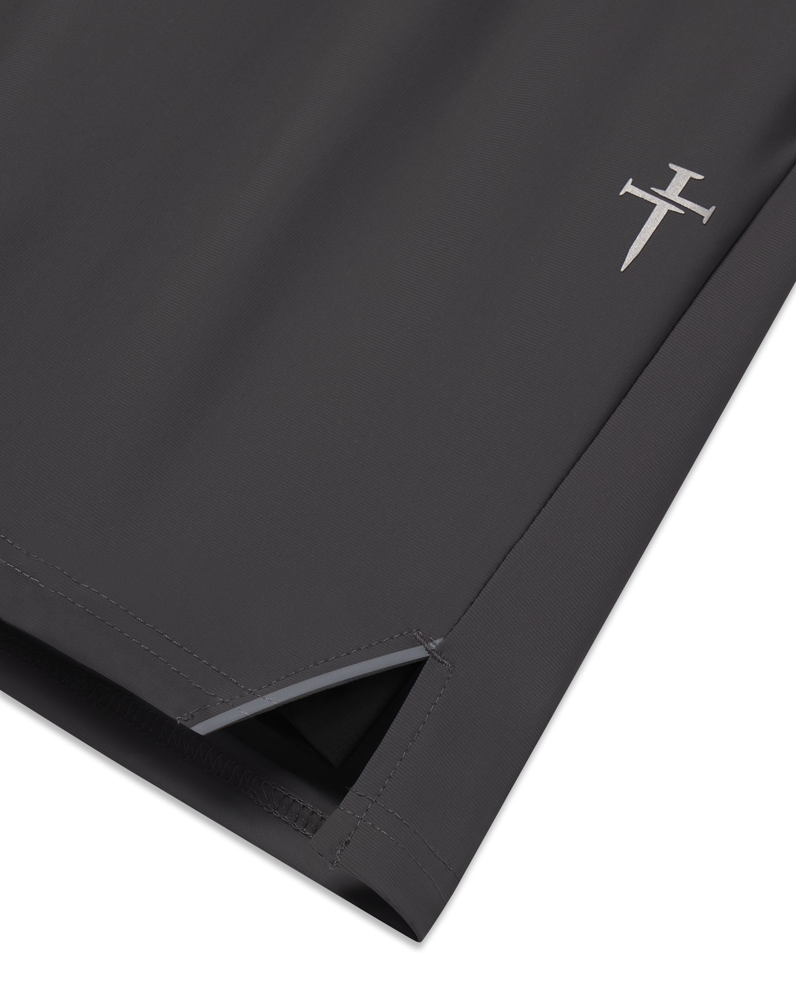 Close-up of Space Grey Vapor-Lite Liner Short showing side split hem and embroidered cross logo detail.