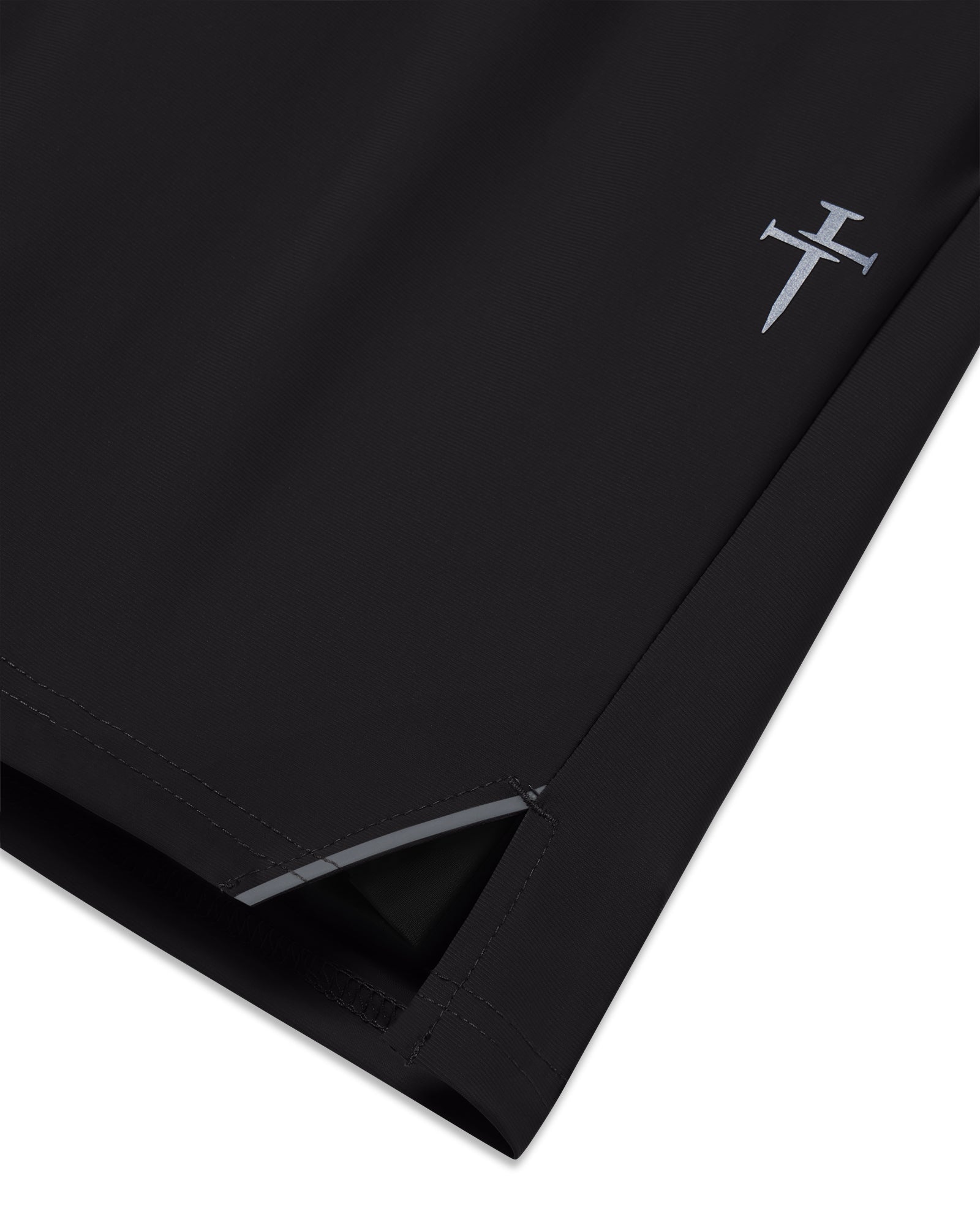 Close-up of black Vapor-Lite Liner Short Cross showing side hem slit, stitching detail, and small cross logo.