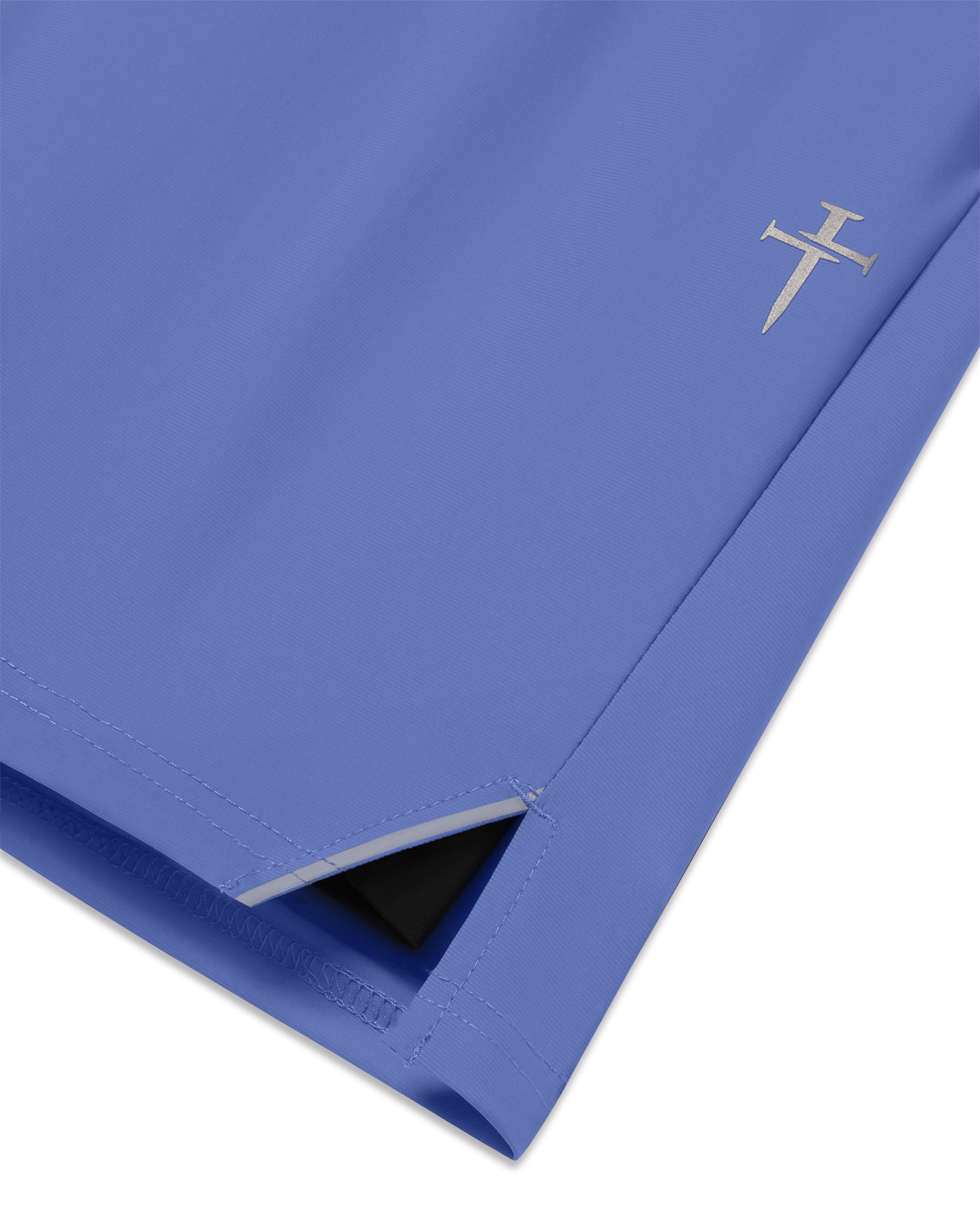 Close-up of Vapor-Lite Liner Short in Serene Blue showing side slit hem, inner liner, and silver cross logo detail.