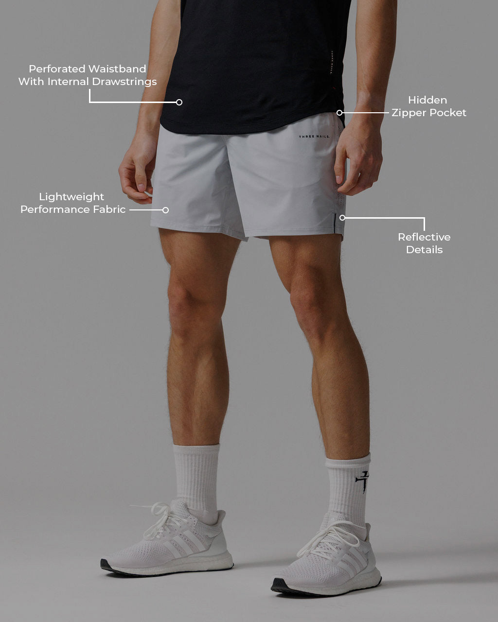 Man wearing Vapor-Lite Hybrid Short in Stone, front angle view, with feature callouts highlighting key design details.