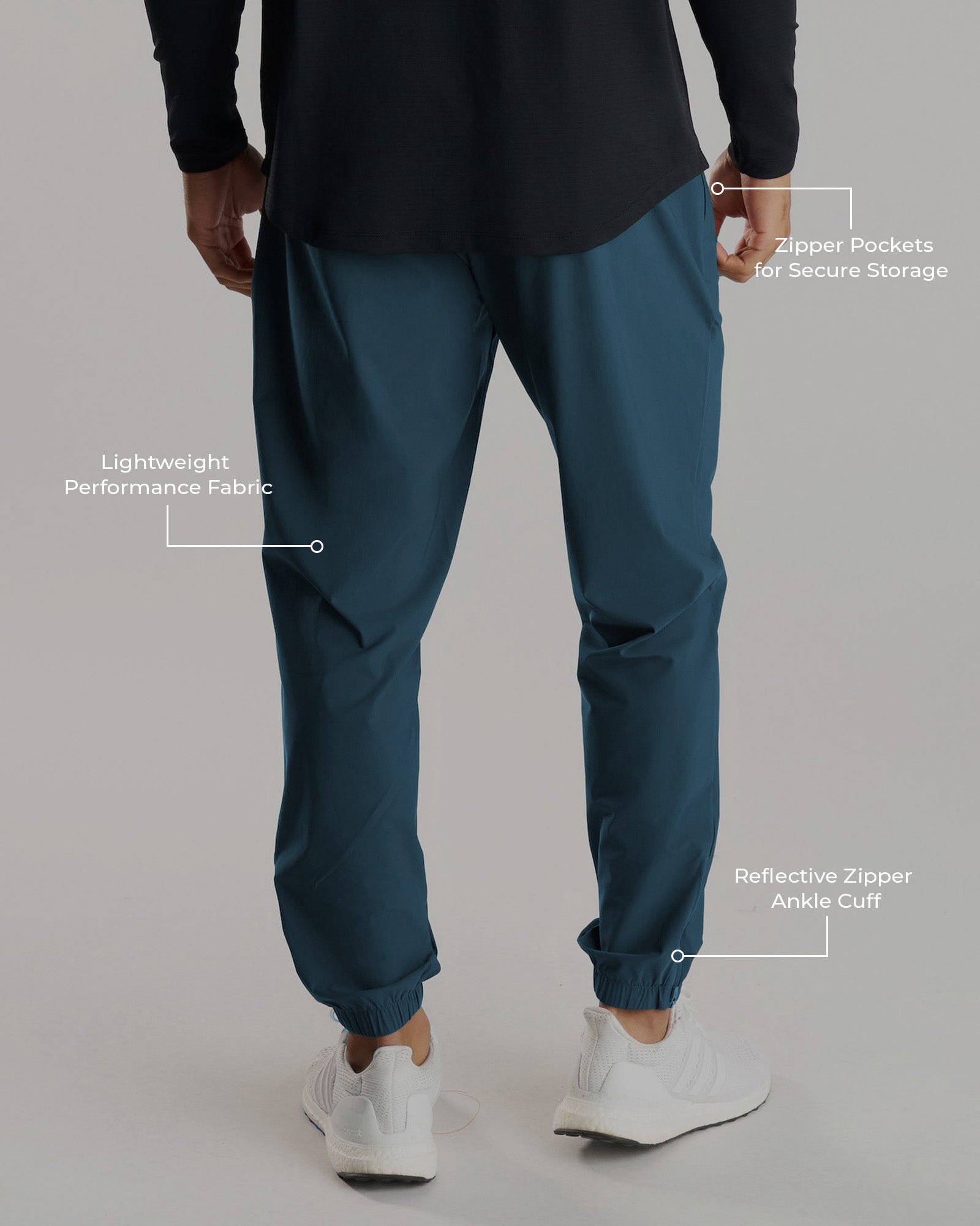 Back view of the Vapor-Lite Jogger in Midnight Navy with annotated features including zipper pockets and ankle cuffs.