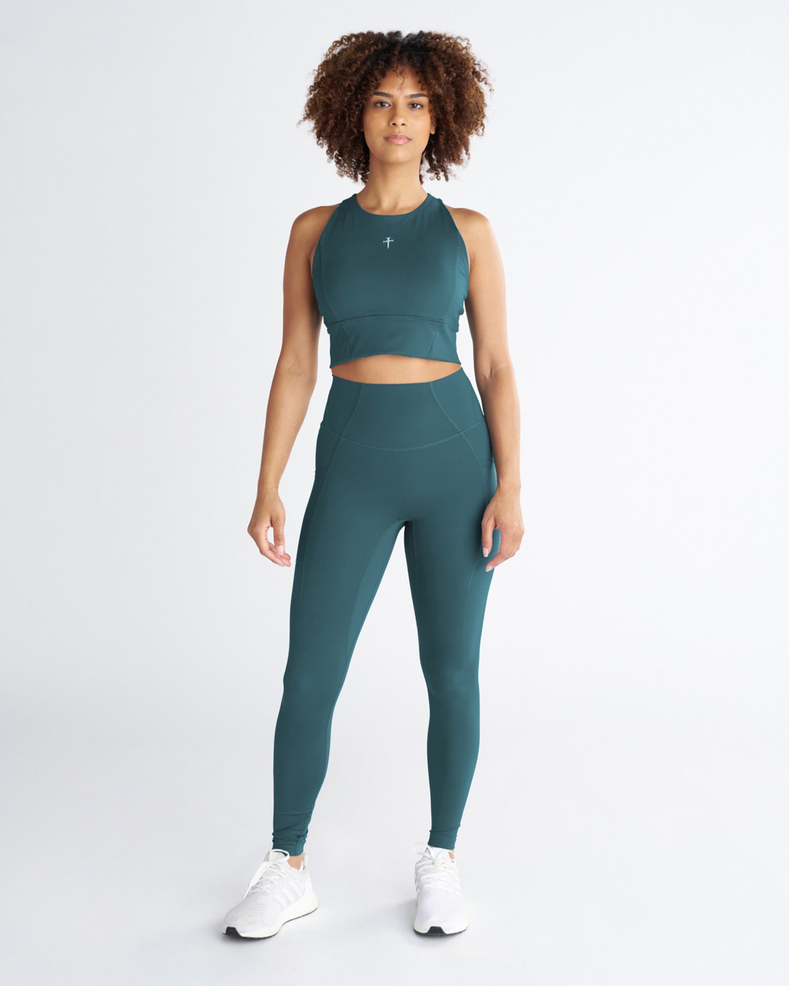 Front view of Endura-Train Pocket Legging in Teal worn by a model standing upright, paired with matching crop top.