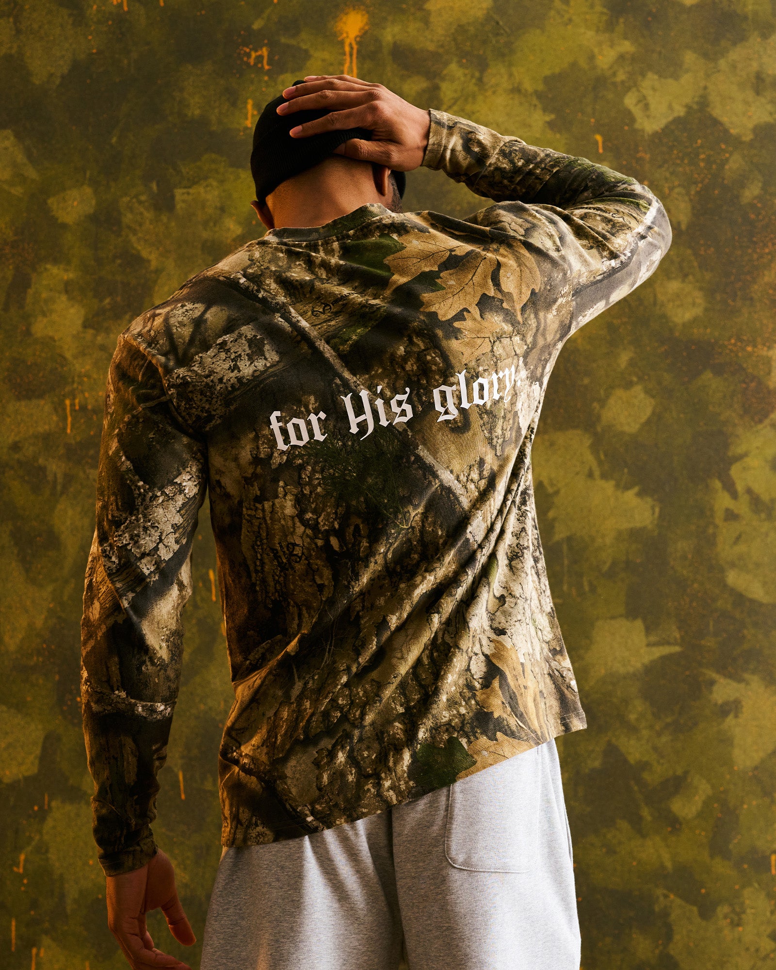 Back view of model wearing Heavyweight Cotton Oversized Long Sleeve FHG in Realtree Camo with for His glory text on back.