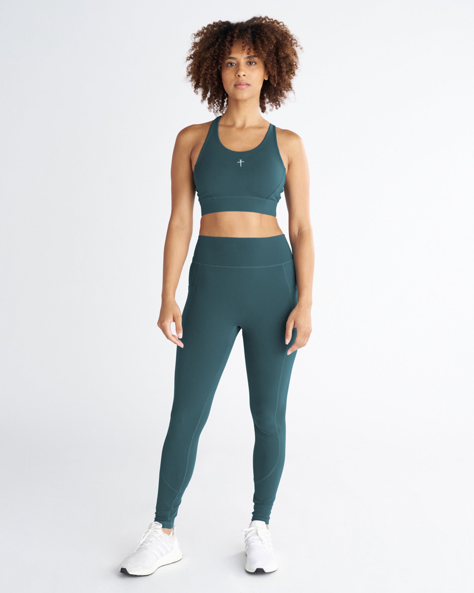 Front view of Nova Pocket Legging 27" in Teal styled with matching sports bra on a standing model.