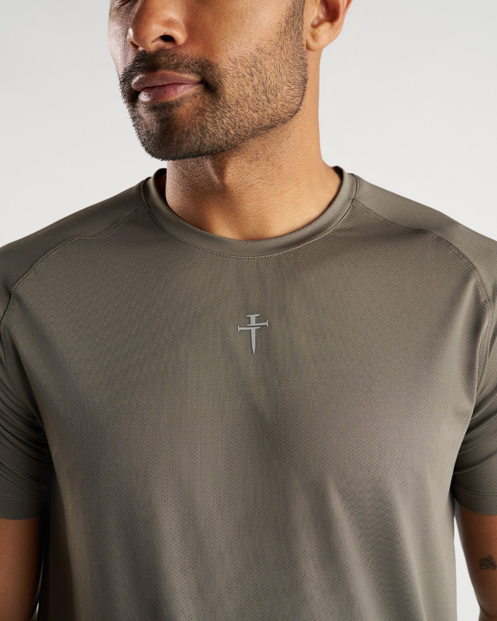 Close-up front view of the Pro-Tech Tee Cross in Sage showing the tonal cross logo on chest.
