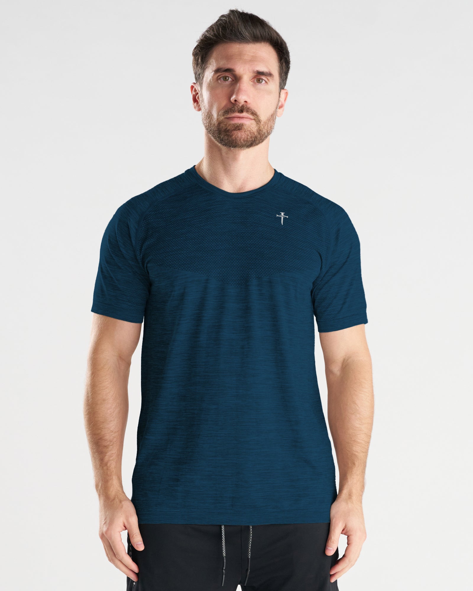 Man wearing the Seamless Tee in Midnight Navy, front view, featuring subtle texture paneling and a small logo at chest.